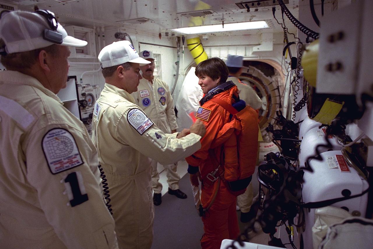 STS-94 Payload Commander Janice Voss prepares to enter the Space Shuttle Columbia at Launch Pad 39A in preparation for launch.  She has flown on STS-83, STS-63 and STS-57. Voss holds a  doctorate degree in aeronautics/astronautics from the Massachusetts Institute of  Technology and has earned two NASA Space Flight Medals. As Payload Commander and  a member of the Blue team, Voss will have overall responsibility for the operation of  all  of the  MSL-1  experiments. During the experimentation phase of the mission, she be  working primarily with three combustion experiments. She and six fellow crew members  will lift off  during a launch window that opens at 1:50 p.m. EDT,  July 1. The launch window will open 47 minutes early to improve the opportunity to  lift off before Florida summer rain showers reach the space center