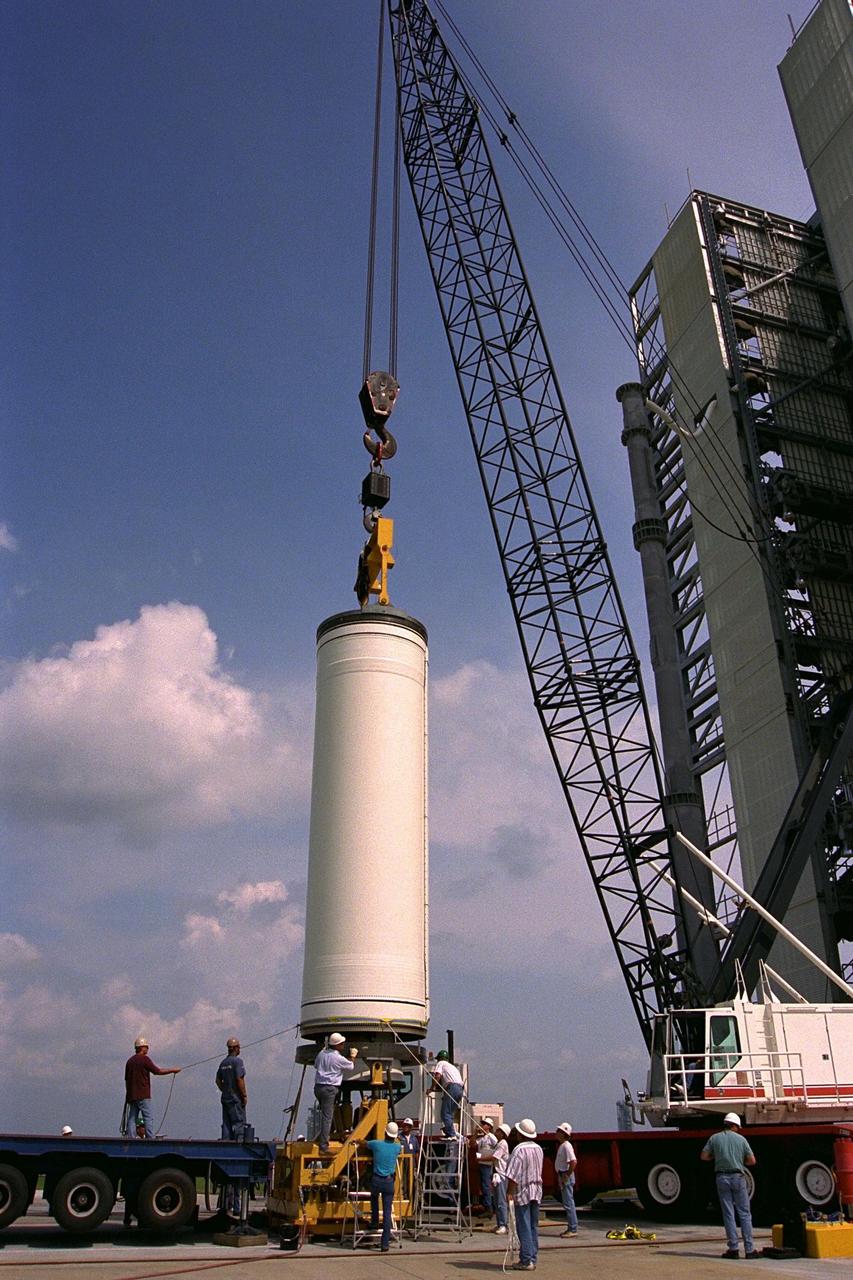 Workers erect the first stage of a Lockheed  Martin Launch Vehicle-2 (LMLV-2) at Launch Complex 46 at Cape Canaveral Air  Station, Fla. The Lunar Prospector spacecraft is scheduled to launch aboard the LMLV-2  in October for an 18-month mission that will orbit the Earth’s Moon to collect data from  the lunar surface. Designed for a low polar orbit investigation of the Moon, the Lunar  Prospector will map the Moon’s surface composition and possible polar ice deposits,  measure magnetic and gravity fields, and study lunar outgassing events