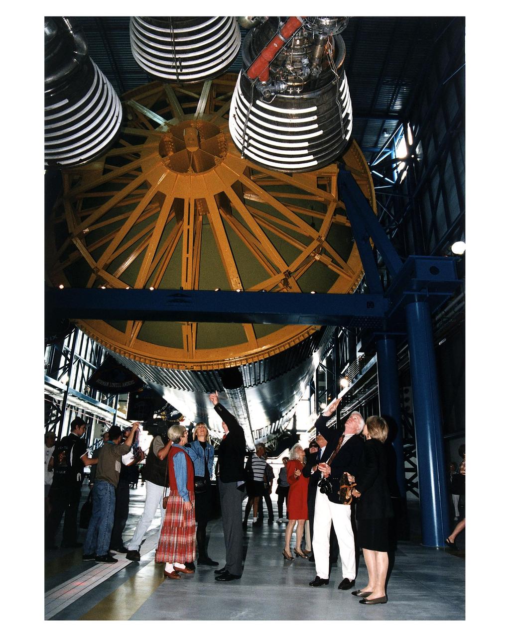 KENNEDY SPACE CENTER, FLA. -- Some of the former Apollo program astronauts tour the new Apollo/Saturn V Center (ASVC) at KSC prior to the gala grand opening ceremony for the facility that was held Jan. 8, 1997. The astronauts were invited to participate in the event, which also featured NASA Administrator Dan Goldin and KSC Director Jay Honeycutt. Apollo 10 Lunar Module Pilot and Apollo 17 Commander Eugene A. Cernan and Apollo 9 Lunar Module Pilot Russell L. Schweickart (second from right), are both pointing at the KSC Apollo/Saturn V rocket inside the building as they talk to other guests on the tour. The ASVC also features several other Apollo program spacecraft components, multimedia presentations and a simulated Apollo/Saturn V liftoff. The facility will be a part of the KSC bus tour that embarks from the KSC Visitor Center