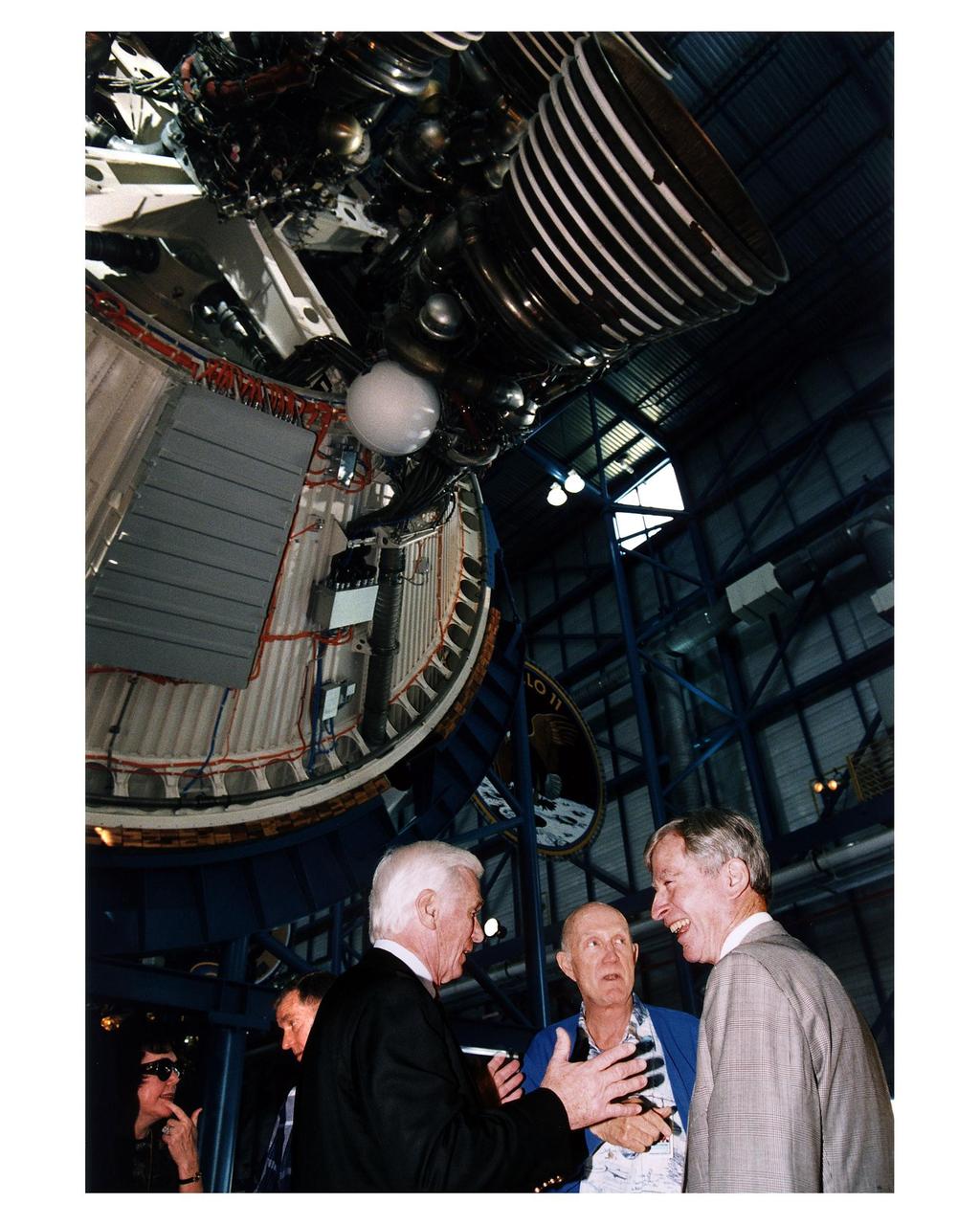 KENNEDY SPACE CENTER, FLA. -- Some of the former Apollo program astronauts tour the new Apollo/Saturn V Center (ASVC) at KSC prior to the gala grand opening ceremony for the facility that was held Jan. 8, 1997. The astronauts were invited to participate in the event, which also featured NASA Administrator Dan Goldin and KSC Director Jay Honeycutt. Discussing old times beneath the KSC Apollo/Saturn V rocket inside the building are (from left) Apollo 10 Lunar Module Pilot and Apollo 17 Commander Eugene A. Cernan; Apollo 10 Commander Thomas P. Stafford and Apollo 16 Commander John W. Young. The ASVC also features several other Apollo program spacecraft components, multimedia presentations and a simulated Apollo/ Saturn V liftoff. The facility will be a part of the KSC bus tour that embarks from the KSC Visitor Center