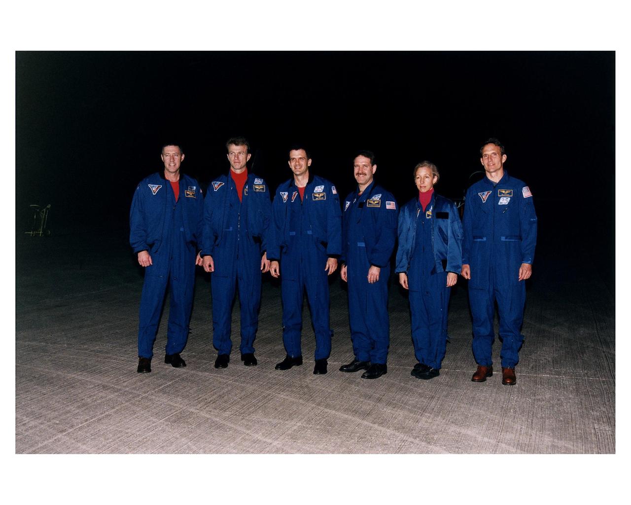 The STS-81 flight crew poses on the runway of KSC Shuttle Landing Facility after they arrive at the space center for the final countdown preparations for the fifth Shuttle-Mir docking mission. They are (from left): Mission Commander Michael A. Baker; Pilot Brent W. Jett, Jr.; and Mission Specialists Peter J. K. "Jeff" Wisoff; John M. Grunsfeld, Marsha S. Ivins, and J.M. "Jerry" Linenger. The 10-day mission will feature the transfer of Linenger to Mir to replace astronaut John Blaha, who has been on the orbital laboratory since Sept. 19, 1996 after arrival there during the STS-79 mission. During STS-81, Shuttle and Mir crews will conduct risk mitigation, human life science, microgravity and materials processing experiments that will provide data for the design, development and operation of the International Space Station. The primary payload is the SPACEHAB-DM double module which will provide space for more than 2,000 pounds of hardware, food and water that will be transferred into the Russian space station during five days of docking operations. The SPACEHAB will also be used to return experiment samples from the Mir to Earth for analysis and for microgravity experiments during the mission