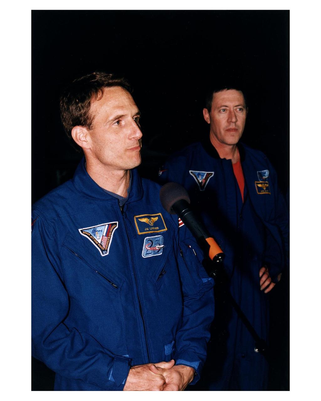 STS-81 Mission Specialist J.M. "Jerry" Linenger talks to the press at the KSC Shuttle Landing Facility after the flight crew arrived at the space center for the final countdown preparations for the fifth Shuttle-Mir docking mission. The 10-day mission will feature the transfer of Linenger to Mir to replace astronaut John Blaha, who has been on the orbital laboratory since Sept. 19, 1996. Linenger will be the fourth U.S. astronaut to stay onboard the Russian space station and serve as a Mir crew member. Mission Commander Michael A. Baker is to his left