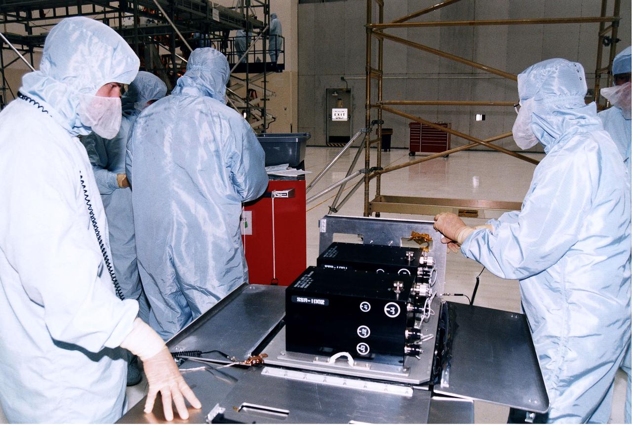 KENNEDY SPACE CENTER, FLA. -  Workers in KSC's Vertical Processing Facility prepare a solid state recorder for installation in a protective enclosure as part of the prelaunch preparations for STS-82, the second Hubble Space Telescope servicing mission.  The digital solid state recorder will replace one of three engineering/science tape recorders on Hubble.  The solid state recorder has no moving parts to wear out.  It also is more flexible than a reel-to-reel recorder and can store 10 times as much data.  Liftoff aboard Discovery is targeted Feb. 11 with a crew of seven.