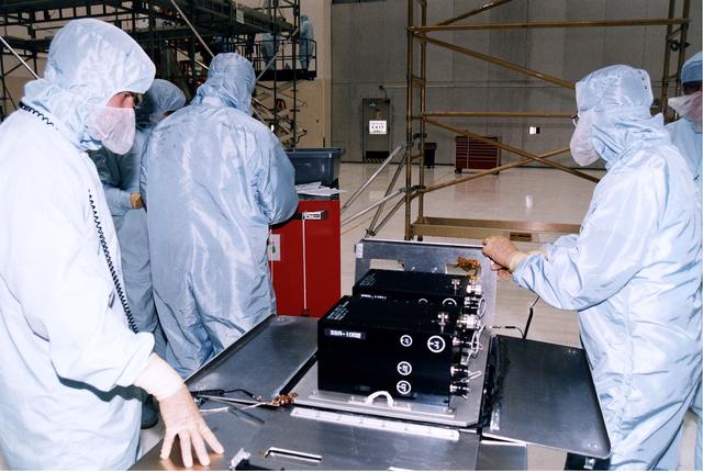 NASA image: KENNEDY SPACE CENTER, FLA. -  Workers in KSC's Vertical Processing Facility prepare a solid state recorder for installation in a protective enclosure as part of the prelaunch preparations for STS-82, the second Hubble Space Telescope servicing mission.  The digital solid state recorder will replace one of three engineering/science tape recorders on Hubble.  The solid state recorder has no moving parts to wear out.  It also is more flexible than a reel-to-reel recorder and can store 10 times as much data.  Liftoff aboard Discovery is targeted Feb. 11 with a crew of seven.