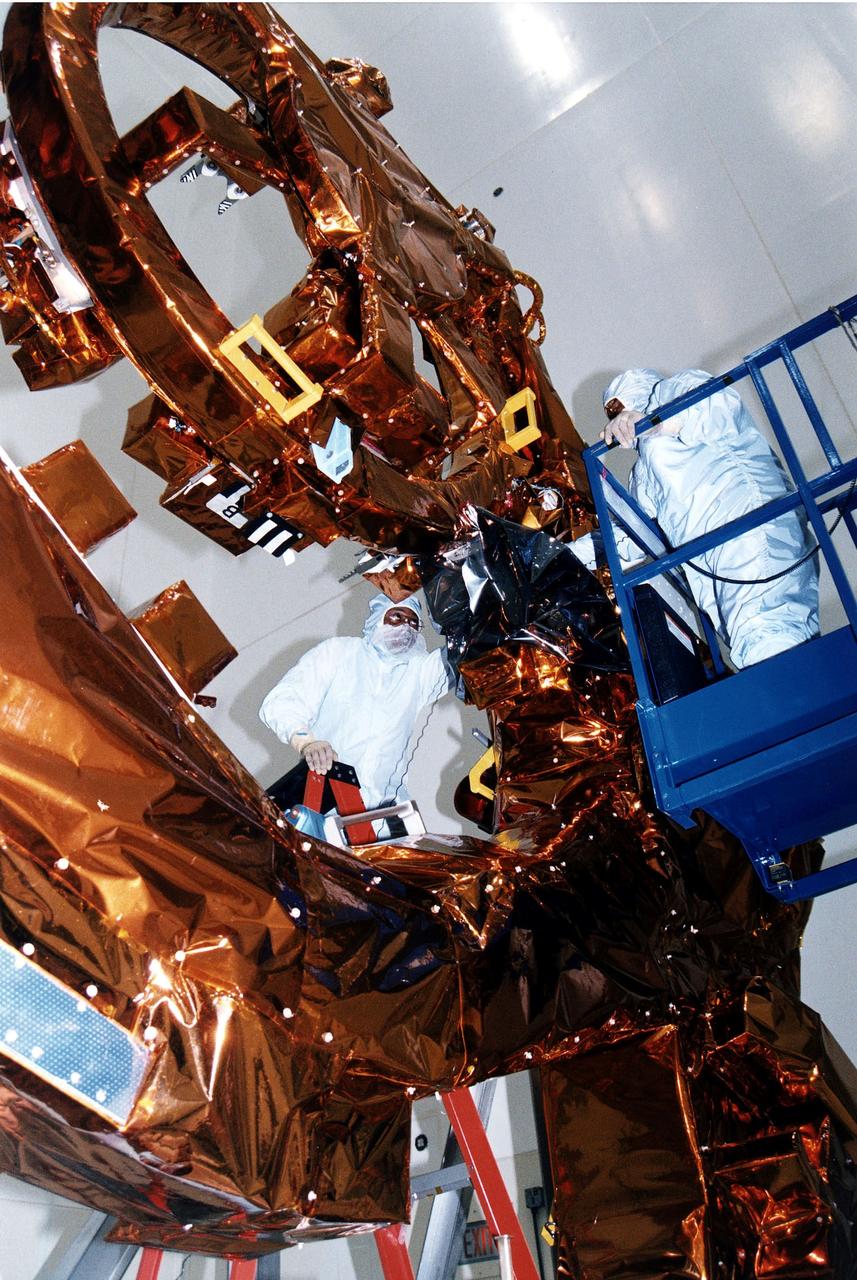 KENNEDY SPACE CENTER, FLA. - Workers in KSC's Vertical Processing Facility make final adjustments to the Flight Support System (FSS) for STS-82, the second Hubble Space Telescope servicing mission. The FSS is reusable flight hardware that provides the mechanical, structural and electrical interfaces between HST, the space support equipment and the orbiter for payload retrieval and on-orbit servicing. Liftoff aboard Discovery is targeted Feb. 11 with a crew of seven.