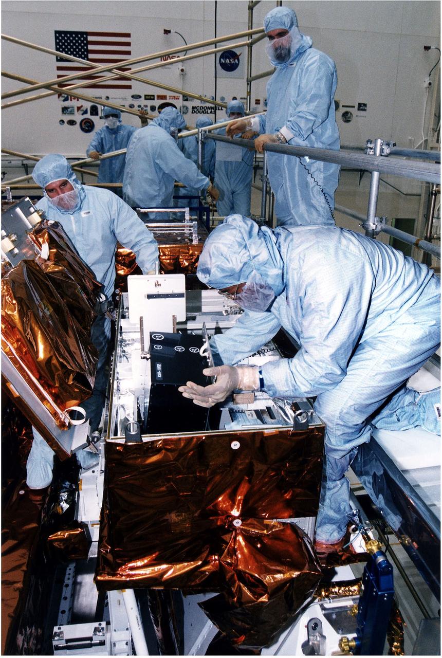 KENNEDY SPACE CENTER, FLA. -  Workers in KSC's Vertical Processing Facility install a solid state recorder into a transport assembly in its protective enclosure as part of the prelaunch preparations for STS-82, the second Hubble Space Telescope servicing mission.  The digital solid state recorder will replace one of three engineering/science tape recorders on Hubble.  The solid state recorder has no moving parts to wear out.  It also is more flexible than a reel-to-reel recorder and can store 10 times as much data.  Liftoff aboard Discovery is targeted Feb. 11 with a crew of seven.