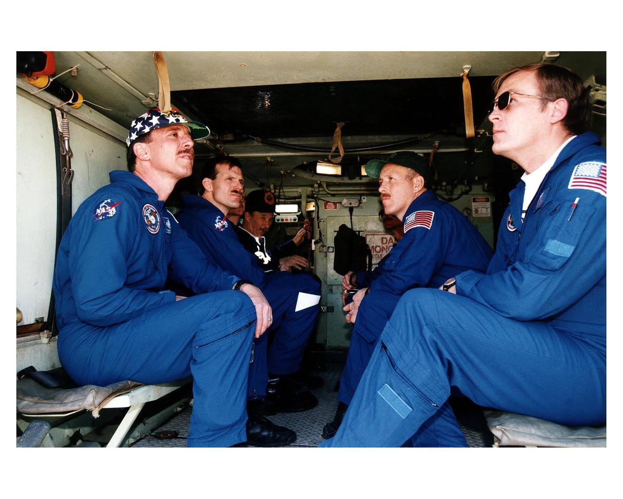 STS-82 crew members ride in and learn how to operate an M-113 armored personnel carrier during Terminal Countdown Demonstration Test (TCDT) activities prior to launch. The four crew members dressed in their blue flight suits and visible here are, from left, Pilot Scott J. "Doc" Horowitz, Mission Specialist Joseph R. "Joe" Tanner, Mission Commander Kenneth D. Bowersox and Payload Commander Mark C. Lee. George Hoggard, a training officer with KSC Fire Services, is visible in the background at left. The 10-day STS-82 flight, which will be the second Hubble Space Telescope servicing mission, is targeted for a Feb. 11 liftoff