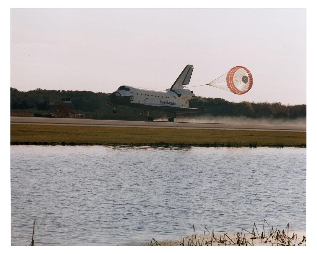 KENNEDY SPACE CENTER, FLA. -- With its drag chute deployed, the Space Shuttle orbiter Atlantis touches down on Runway 33 on the second opportunity at 9:22:44 a.m. EST Jan. 22 to conclude the fifth Shuttle-Mir docking mission and return NASA astronaut John Blaha to Earth after four months in space. At main gear touchdown, the STS-81 mission duration was 10 days, 4 hours, 55 minutes. This was the 34th KSC landing in Shuttle history. Mission Commander Michael A. Baker flew Atlantis to a perfect landing, with help from Pilot Brent W. Jett, Jr. Other returning STS-81 crew members are Mission Specialists John M.Grunsfeld, Peter J. K. "Jeff" Wisoff and Marsha S. Ivins. Atlantis also brought back experiment samples from the Russian space station Mir for analysis on Earth, along with Russian logistics equipment
