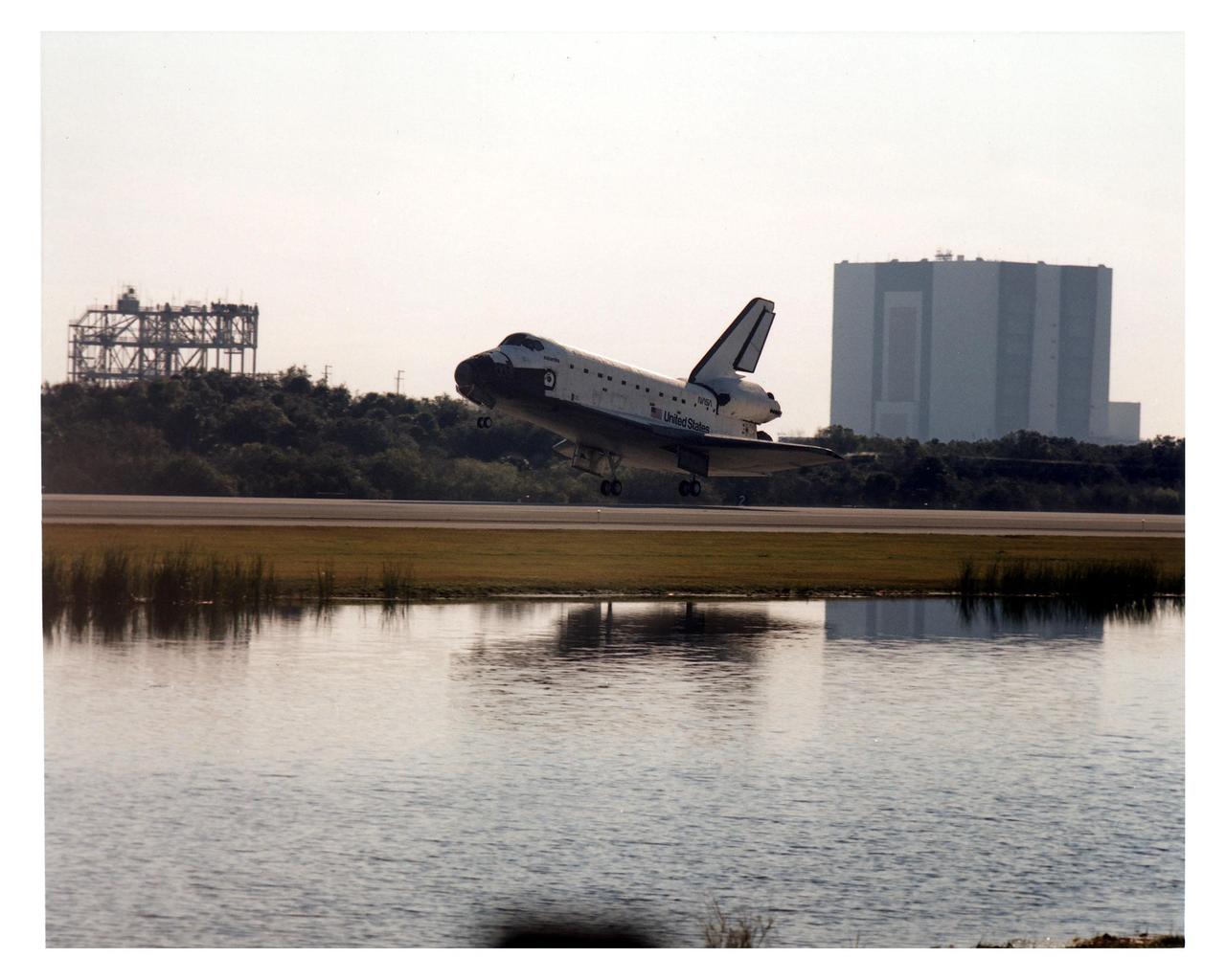 KENNEDY SPACE CENTER, FLA. -- With the Mate/Demate Device (MDD) on the left and the Vehicle Assembly Building (VAB) on the right, the Space Shuttle orbiter Atlantis approaches Runway 33 at KSC’s Shuttle Landing Facility for a scheduled touchdown at about 9:23 a.m. EST Jan. 22. When the orbiter lands, it will conclude the fifth Shuttle-Mir docking mission and return NASA astronaut John Blaha to Earth after four months in space. At main gear touchdown, the STS-81 mission duration will be 10 days, 4 hours, 55 minutes. This is the 34th KSC landing in Shuttle history. Mission Commander Michael A. Baker is steering Atlantis to a perfect landing, with help from Pilot Brent W. Jett, Jr. Other returning STS-81 crew members are Mission Specialists John M. Grunsfeld, Peter J. K. "Jeff" Wisoff and Marsha S. Ivins. Atlantis also brought back experiment samples from the Russian space station Mir for analysis on Earth