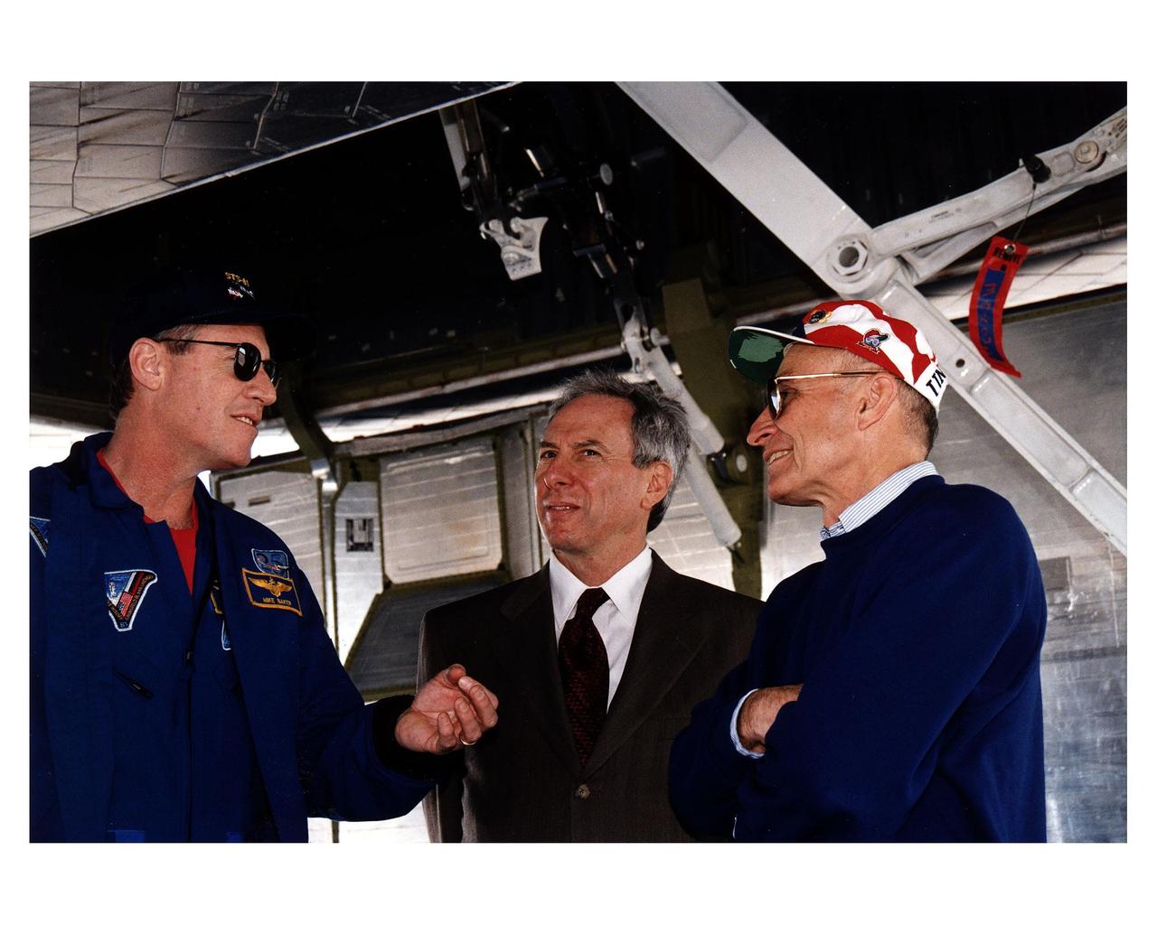 KENNEDY SPACE CENTER, FLA. -- NASA Administrator Daniel S. Goldin (center) and KSC Director of Shuttle Operations Robert B. Sieck (right) discuss the successful conclusion of the STS-81 mission with Mission Commander Michael A. Baker (left). They are underneath the Space Shuttle orbiter Atlantis after the space plane landed on Runway 33 at the KSC Shuttle Landing Facility at 9:22:44 a.m. EST Jan. 22 to conclude the fifth Shuttle-Mir docking mission. At main gear touchdown, the STS-81 mission duration was 10 days, 4 hours, 55 minutes. This was the 34th KSC landing in Shuttle history