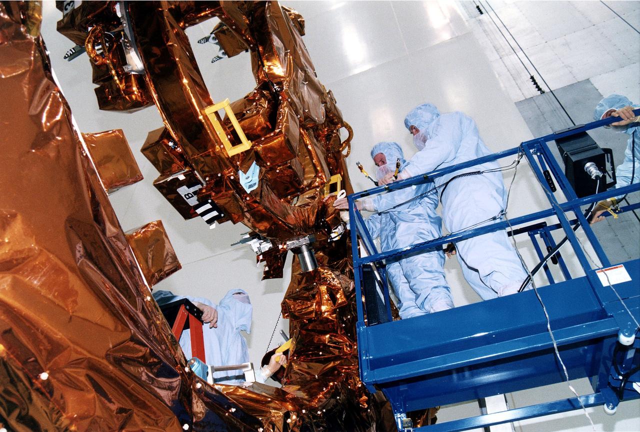 KENNEDY SPACE CENTER, FLA. -  STS-82 crew members examine part of the Flight Support System during the Crew Equipment Integration Test (CEIT) in KSC's Vertical Processing Facility.  From left are Mission Specialists Steven L. Smith and Gregory J. Harbaugh and Payload Commander Mark C. Lee.  Liftoff of STS-82, the second Hubble Space Telescope (HST) servicing mission, is scheduled Feb. 11 aboard Discovery with a crew of seven.