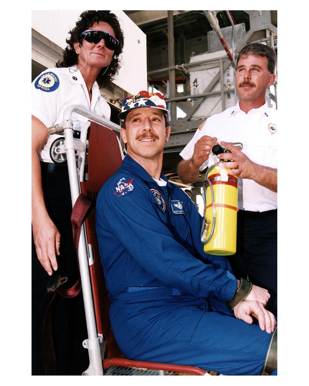 KENNEDY SPACE CENTER, Fla. -- STS-82 Pilot Scott J. "Doc" Horowitz, seated, poses as an immobilized person while pad rescue leaders Kathy Weaver and Steve Kelly of KSC Fire Rescue Services demonstrate the use of flight crew rescue equipment. The demonstration is part of crew training during Terminal Countdown Demonstration Test (TCDT) activities at Launch Pad 39A. The seven-member STS-82 crew will conduct the second Hubble Space Telescope servicing mission. Liftoff of the 10-day flight is scheduled Feb. 11