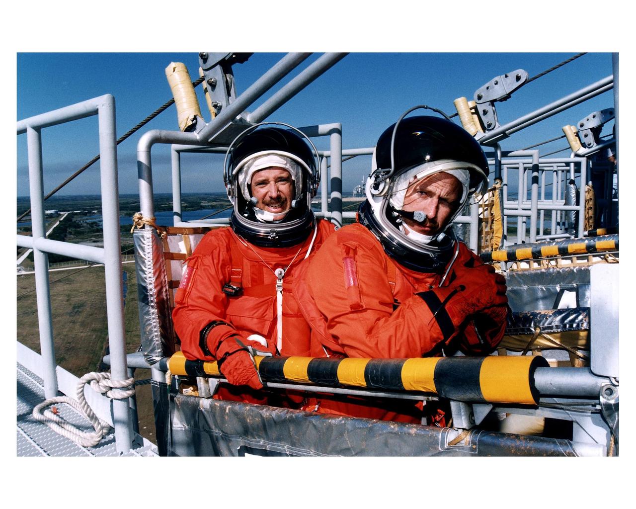 KENNEDY SPACE CENTER, Fla. --STS-82 Mission Commander Kenneth D. Bowersox, at right, and Pilot Scott J. "Doc" Horowitz practice emergency egress procedures in a slidewire basket at Launch Pad 39A as part of Terminal Countdown Demonstration Test (TCDT) activities. STS-82 will be the second Hubble Space Telescope servicing mission. Liftoff is targeted for Feb. 11
