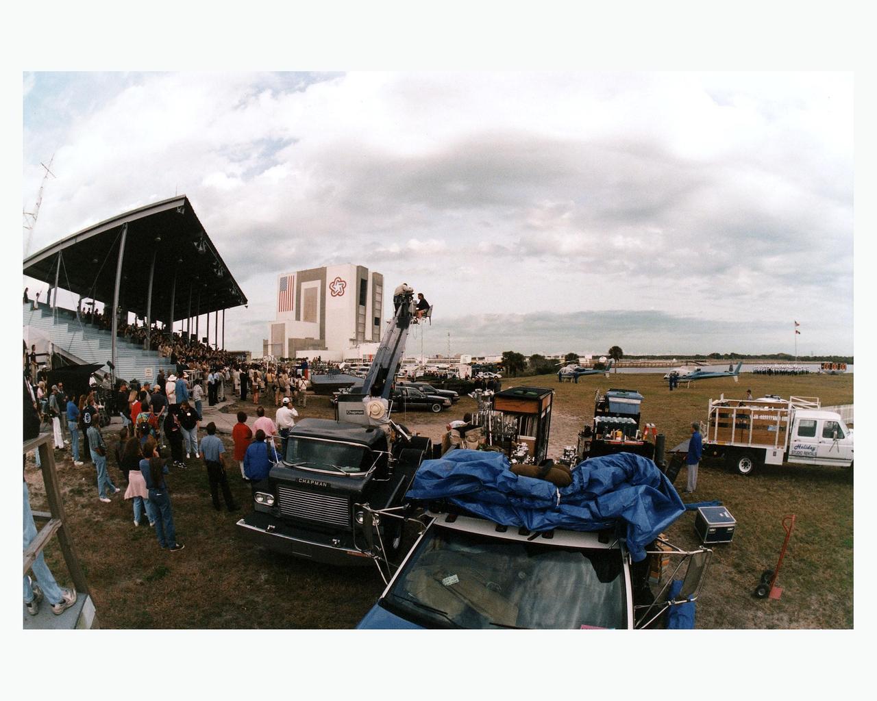 With the Vehicle Assembly Building looming in the background, Warner Bros.' cast and crew are filming scenes for the movie "Contact" at Kennedy Space Center's Launch Complex 39 Press Site on January 29. The screenplay for "Contact" is based on the best-selling novel by the late astronomer Carl Sagan. The cast includes Jodie Foster, Matthew McConaughey, John Hurt, James Woods, Tom Skerritt, David Morse, William Fichtner, Rob Lowe and Angela Bassett. Described by Warner Bros. as a science fiction drama, "Contact" will depict humankind's first encounter with evidence of extraterrestrial life