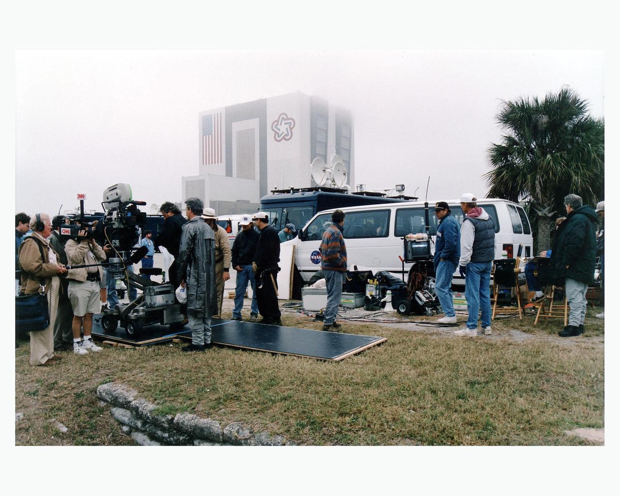 With the Vehicle Assembly Building looming in the background, Warner Bros.' cast and crew are filming scenes for the movie "Contact" at Kennedy Space Center's Launch Complex 39 Press Site on January 30. The screenplay for "Contact" is based on the best-selling novel by the late astronomer Carl Sagan. The cast includes Jodie Foster, Matthew McConaughey, John Hurt, James Woods, Tom Skerritt, David Morse, William Fichtner, Rob Lowe and Angela Bassett. Described by Warner Bros. as a science fiction drama, "Contact" will depict humankind's first encounter with evidence of extraterrestrial life