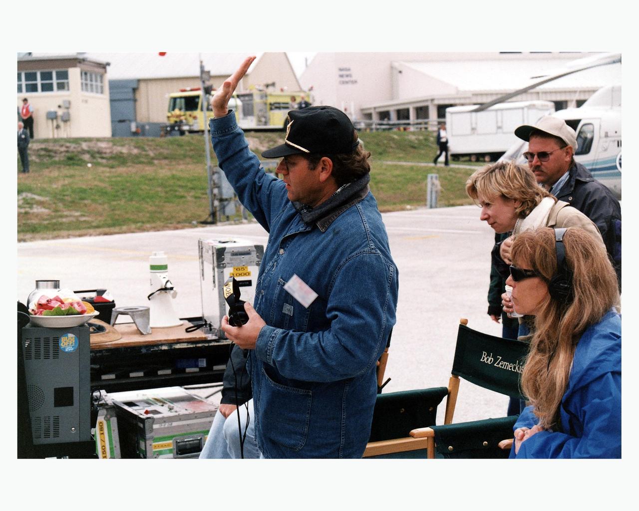 Robert Zemeckis, director/producer, and other Warner Bros. crew members oversee the filming of scenes for the movie "Contact" at Kennedy Space Center's Launch Complex 39 Press Site on January 30. The screenplay for "Contact" is based on the best-selling novel by the late astronomer Carl Sagan. The cast includes Jodie Foster, Matthew McConaughey, John Hurt, James Woods, Tom Skerritt, David Morse, William Fichtner, Rob Lowe and Angela Bassett. Described by Warner Bros. as a science fiction drama, "Contact" will depict humankind's first encounter with evidence of extraterrestrial life
