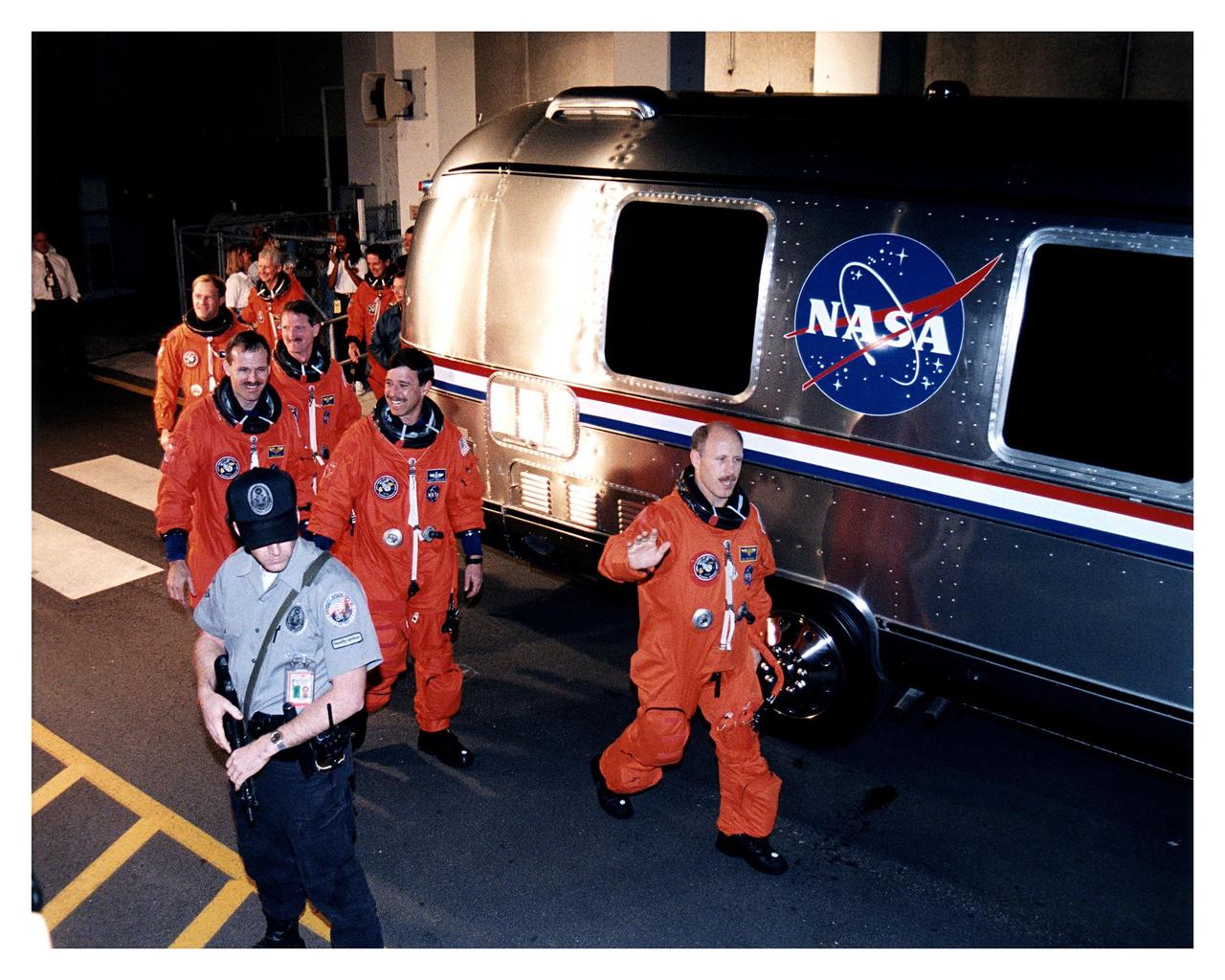 STS-82 Mission Commander Kenneth D. Bowersox leads the way to the astronaut van as the crew departs from the Operations and Checkout Building en route to Launch Pad 39A, where the Space Shuttle Discovery awaits liftoff on a 10-day mission to service the Hubble Space Telescope (HST). Directly behind him is Pilot Scott J. "Doc" Horowitz. The other five crew members, clockwise from left, are Mission Specialist Steven L. Smith, Payload Commander Mark C. Lee, and Mission Specialists Steven A. Hawley, Gregory J. Harbaugh and Joseph R. "Joe" Tanner