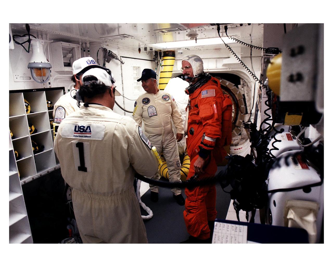 STS-82 Mission Specialist Joseph R. "Joe" Tanner talks to white room closeout crew members before entering the Space Shuttle Discovery at Launch Pad 39A