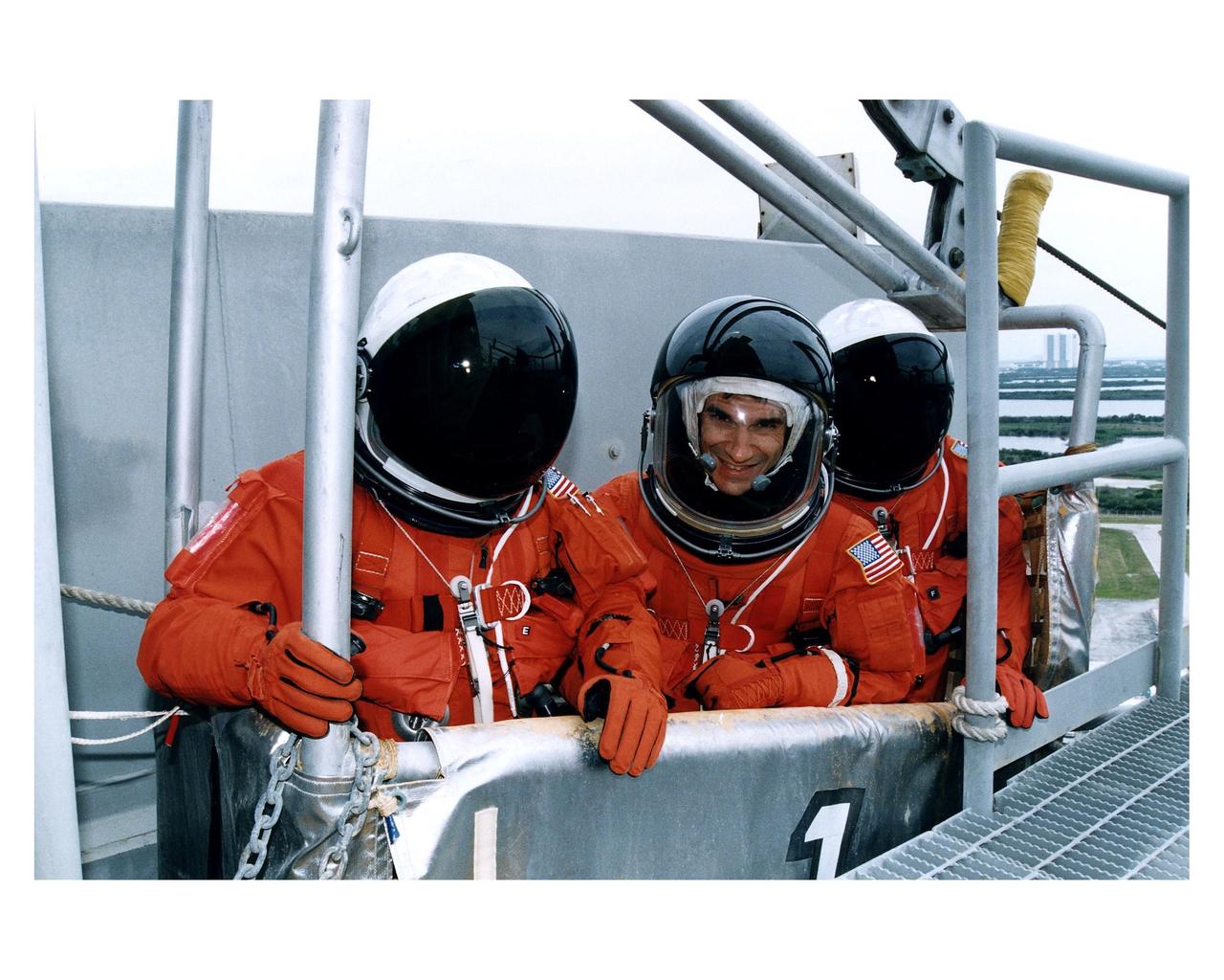 Three members of the STS-83 flight crew check out one of the baskets for the emergency egress slidewire system at Launch Pad 39A during Terminal Countdown Demonstration Test (TCDT) exercises for that mission. Payload Specialist Gregory T. Linteris is in the center of the group. Other crew members on the 16-day Microgravity Science Laboratory-1 (MSL-1) mission are: Mission Commander James D. Halsell, Jr.; Pilot Susan L. Still; Payload Commander Janice Voss; Mission Specialists Michael L. Gernhardt and Donald A. Thomas; and Payload Specialist Roger K. Crouch