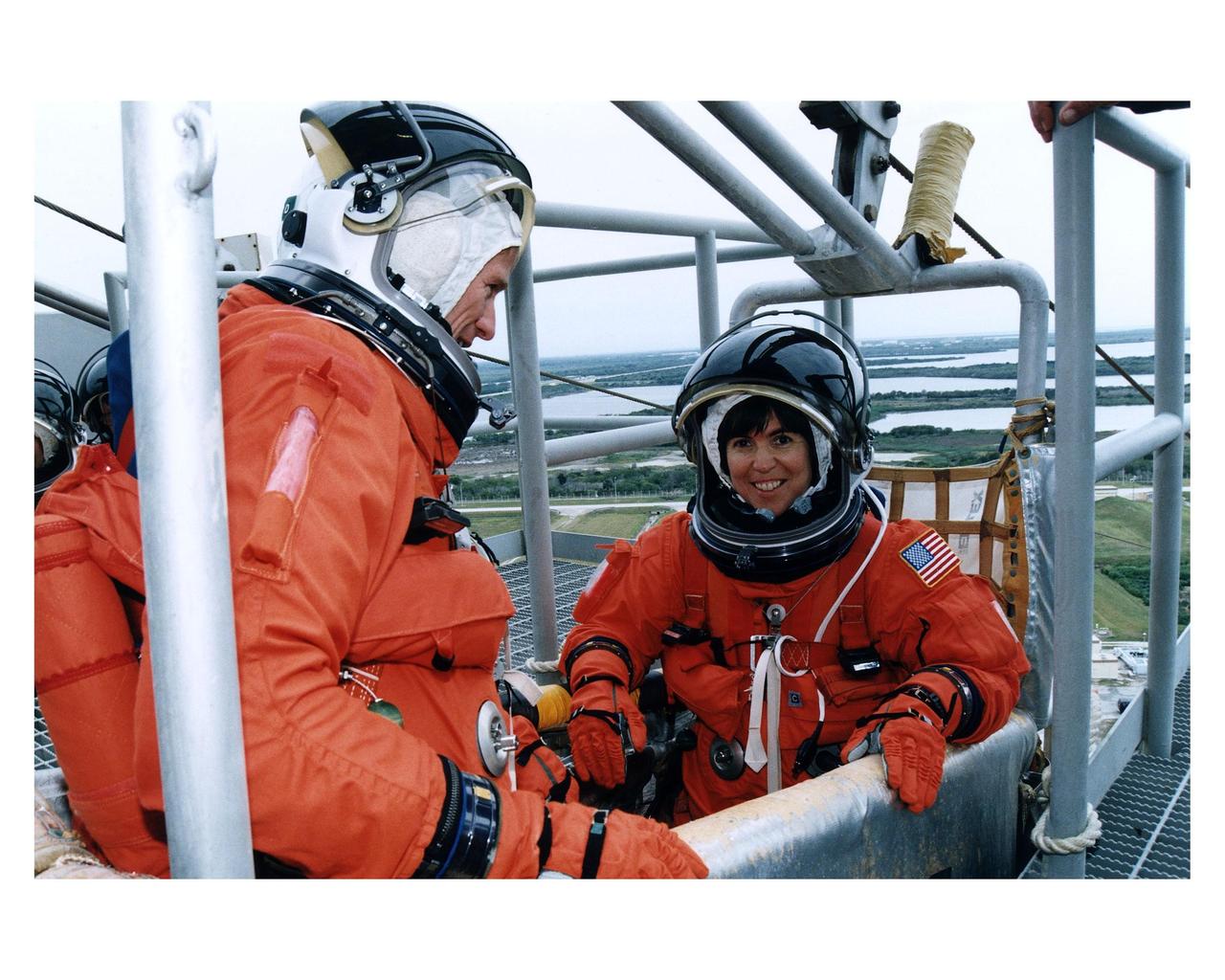 STS-83 Mission Specialist Michael L. Gernhardt and Payload Commander Janice Voss check out one of the baskets for the emergency egress slidewire system at Launch Pad 39A during Terminal Countdown Demonstration Test (TCDT) exercises for that mission. Mission Specialist Donald A. Thomas can be seen to the far left. Other crew members on the 16-day Microgravity Science Laboratory1 (MSL-1) mission are: Mission Commander James D. Halsell, Jr.; Pilot Susan L. Still; and Payload Specialists Gregory T. Linteris and Roger K. Crouch