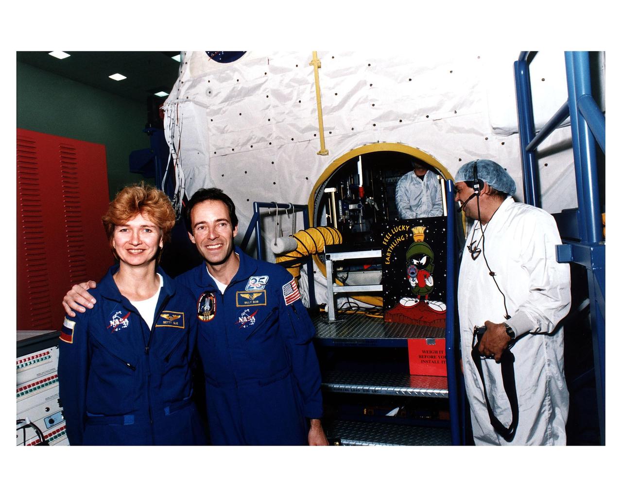 STS-84 Mission Specialists Elena V. Kondakova, at left, and Jean-Francois Clervoy pose for photos outside the SPACEHAB Double Module, which will carry more than 6,000 pounds of scientific experiments and logistics to the Russian Space Station Mir. Kondakova, a cosmonaut with the Russian Space Agency, has the nickname of Betty Sue for this mission. Clervoy, an astronaut with the European Space Agency, is wearing a name tag with his mission nickname, Billie Bob. They are participating in the Crew Equipment Integration Test (CEIT) at the SPACEHAB Payload Processing Facility in Cape Canaveral. STS-84 will be the sixth docking of the Space Shuttle with Mir. It also will be the third consecutive crew member exchange of U.S. astronauts aboard Mir. STS-84 Mission Specialist C. Michael Foale will replace astronaut Jerry M. Linenger on Mir. Linenger has been on Mir since the STS-81 mission in January. Foale is scheduled to remain on Mir about four months. STS-84 is targeted for a May 15 liftoff