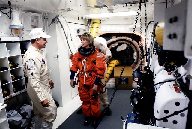 NASA image: KENNEDY SPACE CENTER, FLA. - STS-83 Pilot Susan L. Still chats with White Room closeout crew member Rene Arriens as she prepares to enter the Space Shuttle Columbia at Launch Pad 39A with assistance from closeout crew worker Bob Saulnier (behind Still).