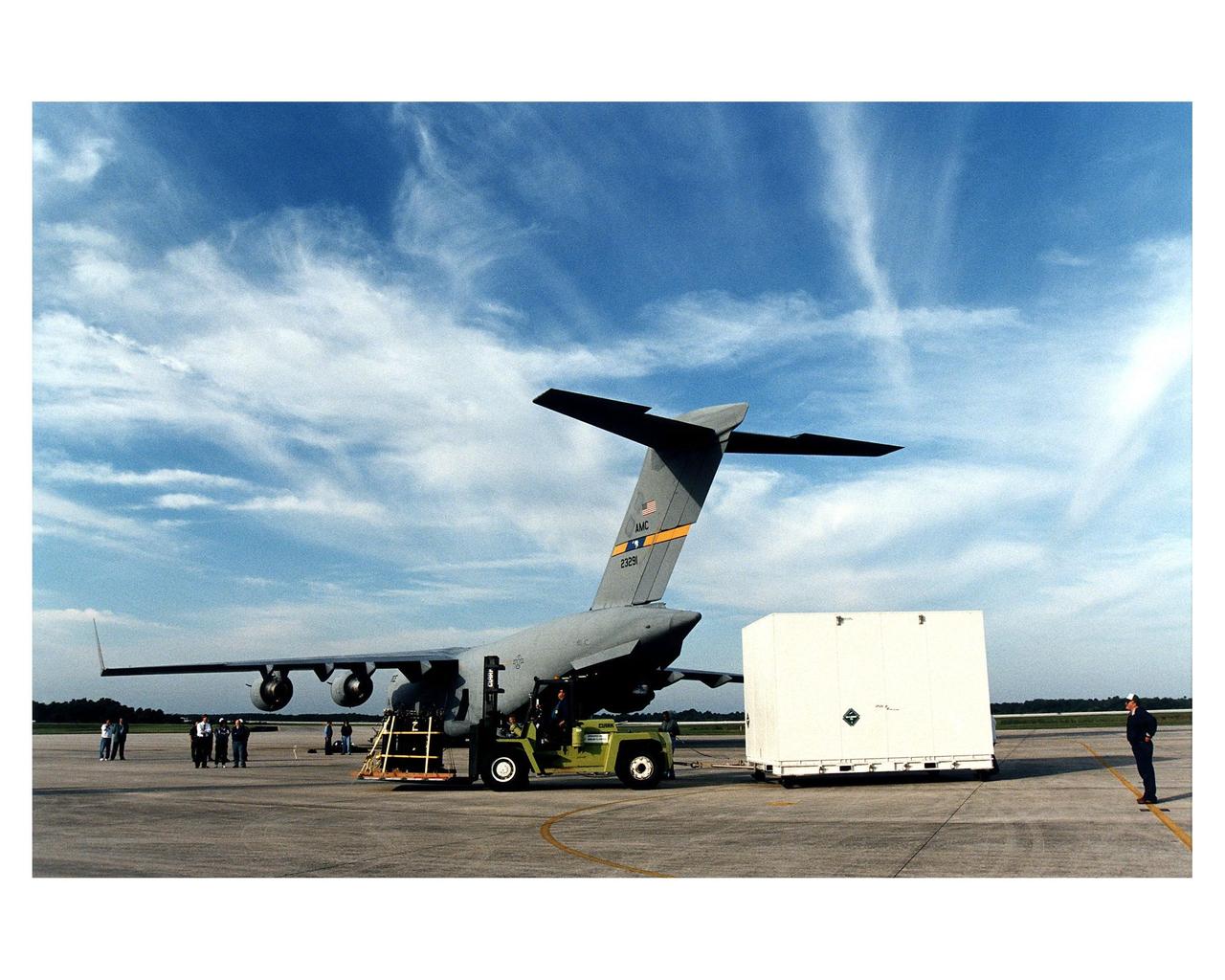 Workers prepare to tow away the large container with the Cassini orbiter from KSC’s Shuttle Landing Facility. The orbiter <a href="http://www-pao.ksc.nasa.gov/kscpao/release/1997/66-97.htm">just arrived</a> on the U.S. Air Force C-17 air cargo plane, shown here, from Edwards Air Force Base, California. The orbiter and the Huygens probe already being processed at KSC are the two primary components of the Cassini spacecraft, which will be launched on a Titan IVB/Centaur expendable launch vehicle from Cape Canaveral Air Station. Cassini will explore Saturn, its rings and moons for four years. The Huygens probe, designed and developed for the European Space Agency (ESA), will be deployed from the orbiter to study the clouds, atmosphere and surface of Saturn’s largest moon, Titan. The orbiter was designed and assembled at NASA’s Jet Propulsion Laboratory in California. Following postflight inspections, integration of the 12 science instruments not already installed on the orbiter will be completed. Then, the parabolic high-gain antenna and the propulsion module will be mated to the orbiter, followed by the Huygens probe, which will complete spacecraft integration. The Cassini mission is targeted for an Oct. 6 launch to begin its 6.7-year journey to the Saturnian system. Arrival at the planet is expected to occur around July 1, 2004