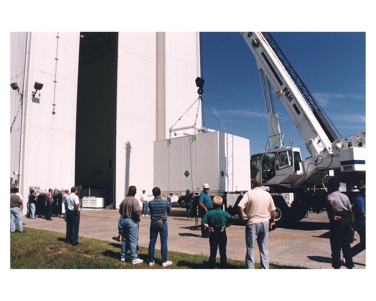 Workers prepare to move the shipping container with the Cassini orbiter inside the Payload Hazardous Servicing Facility (PHSF) for prelaunch processing, testing and integration. The <a href="http://www-pao.ksc.nasa.gov/kscpao/release/1997/66-97.htm">orbiter arrived</a> at KSC’s Shuttle Landing Facility in a U.S. Air Force C-17 air cargo plane from Edwards Air Force Base, California. The orbiter and the Huygens probe already being processed at KSC are the two primary components of the Cassini spacecraft, which will be launched on a Titan IVB/Centaur expendable launch vehicle from Cape Canaveral Air Station. Cassini will explore Saturn, its rings and moons for four years. The Huygens probe, designed and developed for the European Space Agency (ESA), will be deployed from the orbiter to study the clouds, atmosphere and surface of Saturn’s largest moon, Titan. The orbiter was designed and assembled at NASA’s Jet Propulsion Laboratory in California. Following postflight inspections, integration of the 12 science instruments not already installed on the orbiter will be completed. Then, the parabolic high-gain antenna and the propulsion module will be mated to the orbiter, followed by the Huygens probe, which will complete spacecraft integration. The Cassini mission is targeted for an Oct. 6 launch to begin its 6.7-year journey to the Saturnian system. Arrival at the planet is expected to occur around July 1, 2004