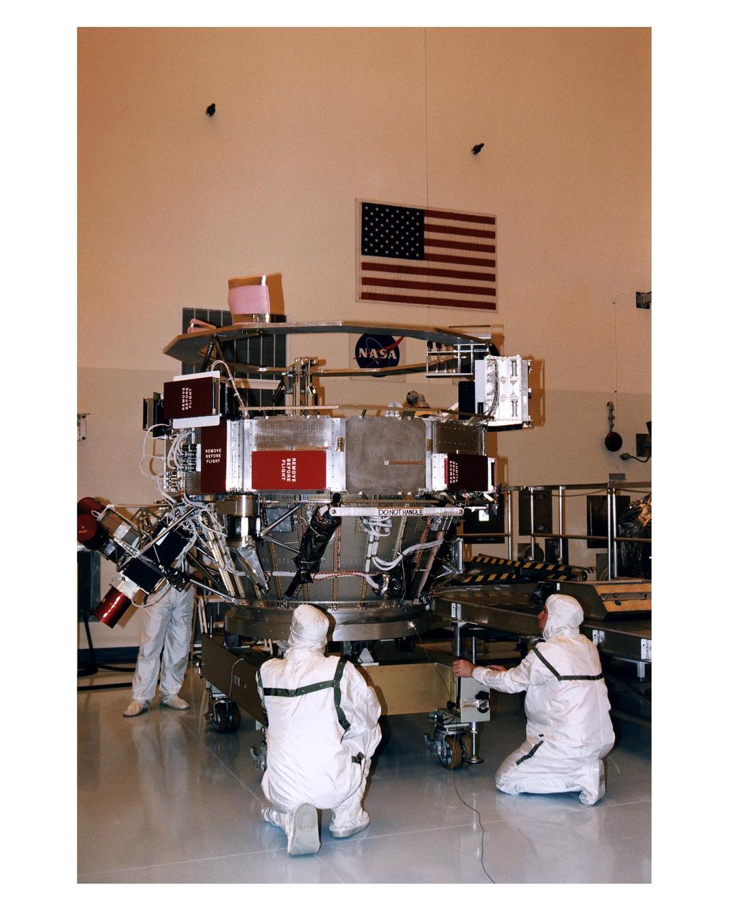Workers in the Payload Hazardous Servicing Facility (PHSF) perform checkouts of the upper experiment module and base of the Cassini orbiter during prelaunch processing, testing and integration in that facility. The Cassini orbiter and Huygens probe being processed at KSC are the two primary components of the Cassini spacecraft, which will be launched on a Titan IVB/Centaur expendable launch vehicle from Cape Canaveral Air Station. Cassini will explore Saturn, its rings and moons for four years. The Huygens probe, designed and developed for the European Space Agency (ESA), will be deployed from the orbiter to study the clouds, atmosphere and surface of Saturn’s largest moon, Titan. The orbiter was designed and assembled at NASA’s Jet Propulsion Laboratory in California. Following postflight inspections, integration of the 12 science instruments not already installed on the orbiter will be completed. Then, the parabolic high-gain antenna and the propulsion module will be mated to the orbiter, followed by the Huygens probe, which will complete spacecraft integration. The Cassini mission is targeted for an Oct. 6 launch to begin its 6.7-year journey to the Saturnian system. Arrival at the planet is expected to occur around July 1, 2004