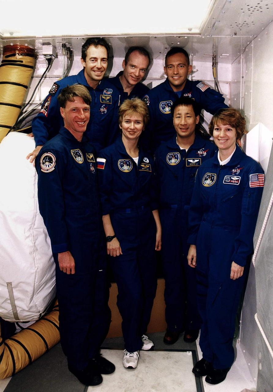 The STS-84 crew pose for a group photograph in front of the crew hatch of the Space Shuttle Atlantis at Launch Pad 39A. In the front row, from left, are Mission Specialists C. Michael Foale, Elena V. Kondakova of the Russian Space Agency, and Edward Tsang Lu; and Pilot Eileen Marie Collins. In the back row, from left, are Mission Specialist Jean-Francois Clervoy of the European Space Agency, Commander Charles J. Precourt and Mission Specialist Carlos I. Noriega. They are at KSC to participate in the Terminal Countdown Demonstration Test (TCDT), a dress rehearsal for launch. STS-84 will be the sixth docking of the Space Shuttle with the Russian Space Station Mir. After docking, Foale will transfer to the space station and become a member of the Mir 23 crew, replacing U.S. astronaut Jerry M. Linenger, who will return to Earth aboard Atlantis. Foale will live and work on Mir until mid-September when his replacement is expected to arrive on the STS-86 mission. STS-84 is targeted for a May 15 liftoff