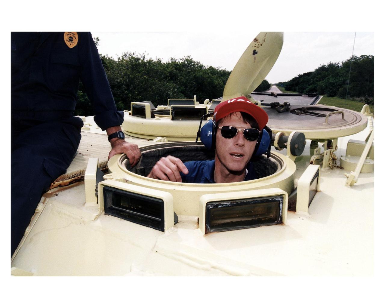 STS-84 Mission Specialist C. Michael Foale rides in an M-113 armored personnel carrier as part of the Terminal Countdown Demonstration Test (TCDT) activities. STS-84 aboard the Space Shuttle Atlantis will be the sixth docking of the Space Shuttle with the Russian Space Station Mir. After docking, Foale will transfer to the space station and become a member of the Mir 23 crew, replacing U.S. astronaut Jerry M. Linenger, who will return to Earth aboard Atlantis. Foale will live and work on Mir until mid-September when his replacement is expected to arrive on the STS-86 mission. STS-84 is targeted for a May 15 liftoff