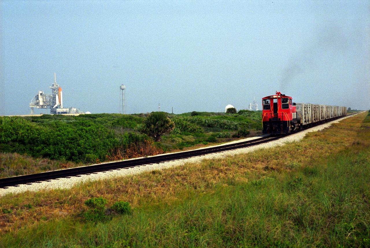 A NASA railroad train moves past Launch Pad 39A at NASA's Kennedy Space Center in Florida. The space agency utilizes railroad operations to not only move equipment at Kennedy, but to transport hardware to and from contractor facilities across the nation. Photo credit: NASA