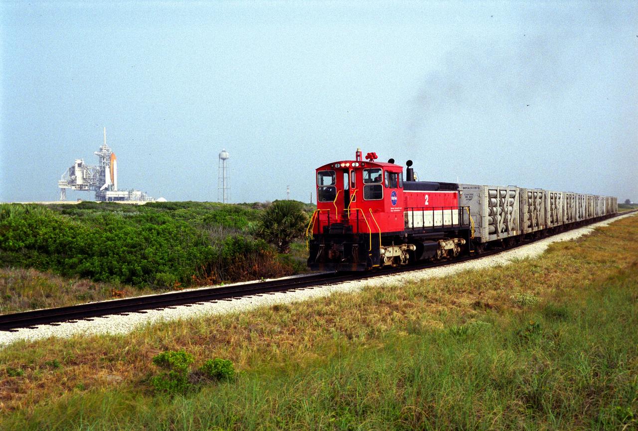 A NASA railroad train moves past Launch Pad 39A at NASA's Kennedy Space Center in Florida. The space agency utilizes railroad operations to not only move equipment at Kennedy, but to transport hardware to and from contractor facilities across the nation. Photo credit: NASA