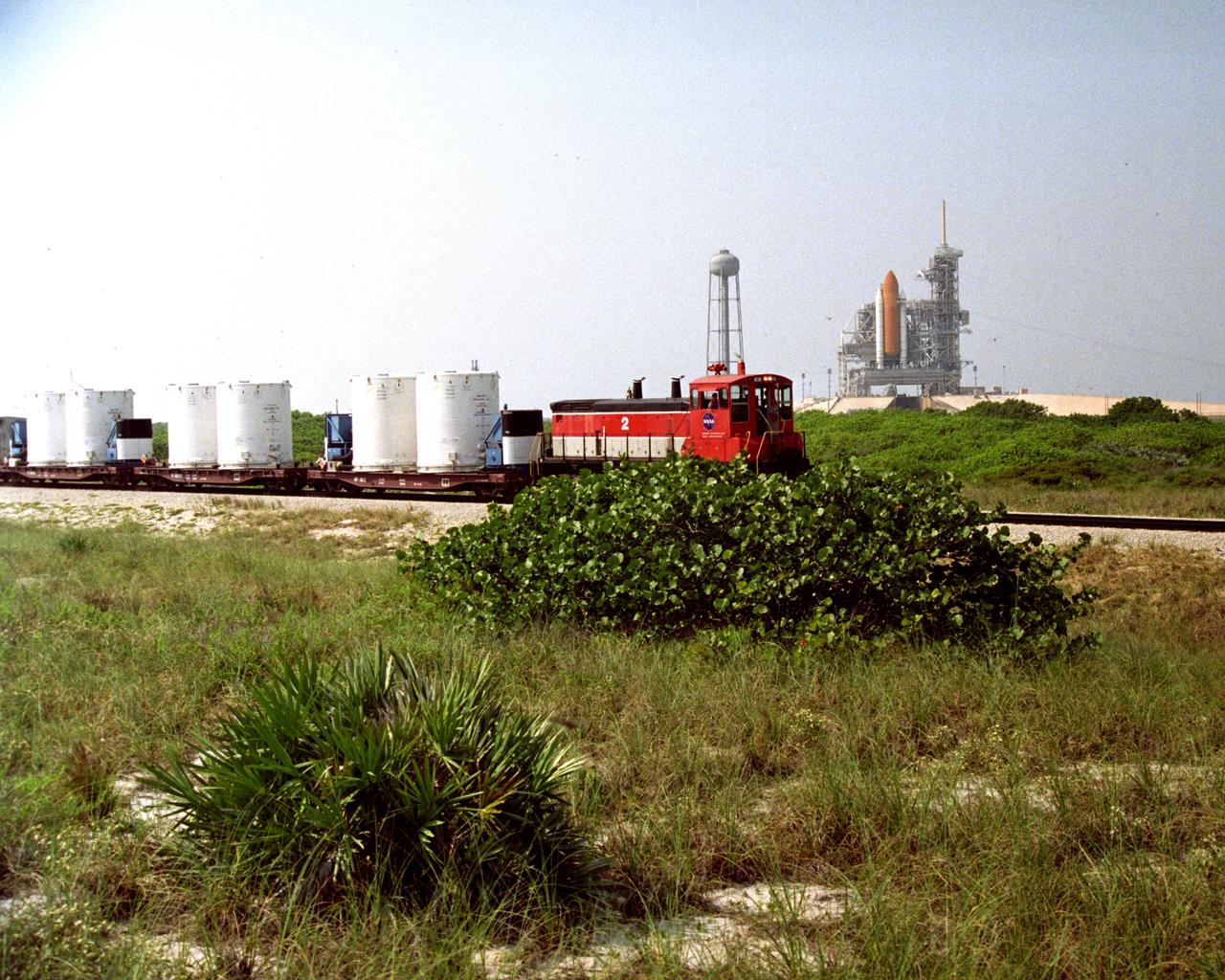 CAPE CANAVERAL, Fla. – A NASA railroad train moves past Launch Pad 39A at NASA's Kennedy Space Center in Florida. The space agency utilizes railroad operations to not only move equipment at Kennedy, but to transport hardware to and from contractor facilities across the nation. Photo credit: NASA