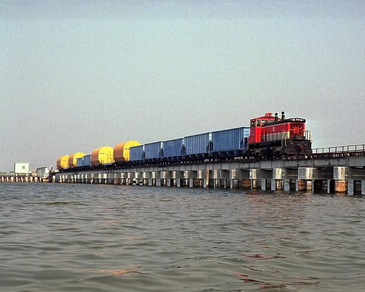 CAPE CANAVERAL, Fla. – A NASA railroad train hauling the solid rocket booster, or SRB, segments moves along the track at NASA's Kennedy Space Center in Florida. The SRB segments are under protective covers. The space agency utilizes railroad operations to not only move equipment at Kennedy, but to transport hardware to and from contractor facilities across the nation. Photo credit: NASA