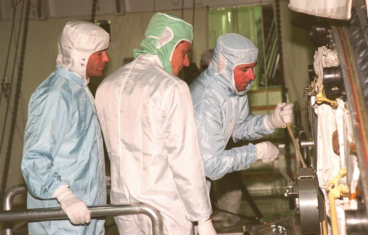 During the Crew Equipment Interface Test (CEIT) in the payload bay of Discovery, STS-95 Mission Specialist Stephen K. Robinson (right) checks a cable that can be used to close a hatch on the orbiter. Looking over his shoulder are Mission Specialist Pedro Duque (center), of the European Space Agency, and Keith Johnson (left), United Space Alliance-Houston. The CEIT gives astronauts an opportunity for a hands-on look at the payloads and equipment they will be using on orbit. The launch of the STS-95 mission, aboard Space Shuttle Discovery, is scheduled for Oct. 29, 1998. The mission includes research payloads such as the Spartan solar-observing deployable spacecraft, the Hubble Space Telescope Orbital Systems Test Platform, the International Extreme Ultraviolet Hitchhiker, as well as the SPACEHAB single module with experiments on space flight and the aging process