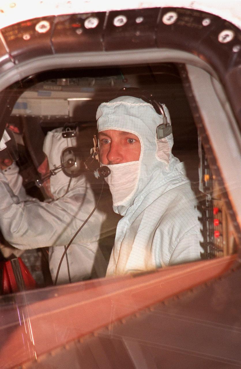 (Foreground) STS-95 Mission Commander Curtis L. Brown Jr. inspects the window of the orbiter Discovery during a Crew Equipment Interface Test (CEIT) for their mission. Pilot Steven Lindsey is in the background. The CEIT gives astronauts an opportunity for a hands-on look at the payloads on which they will be working on orbit. The launch of the STS-95 mission, aboard Space Shuttle Discovery, is scheduled for Oct. 29, 1998. The mission includes research payloads such as the Spartan solar-observing deployable spacecraft, the Hubble Space Telescope Orbital Systems Test Platform, the International Extreme Ultraviolet Hitchhiker, as well as the SPACEHAB single module with experiments on space flight and the aging process