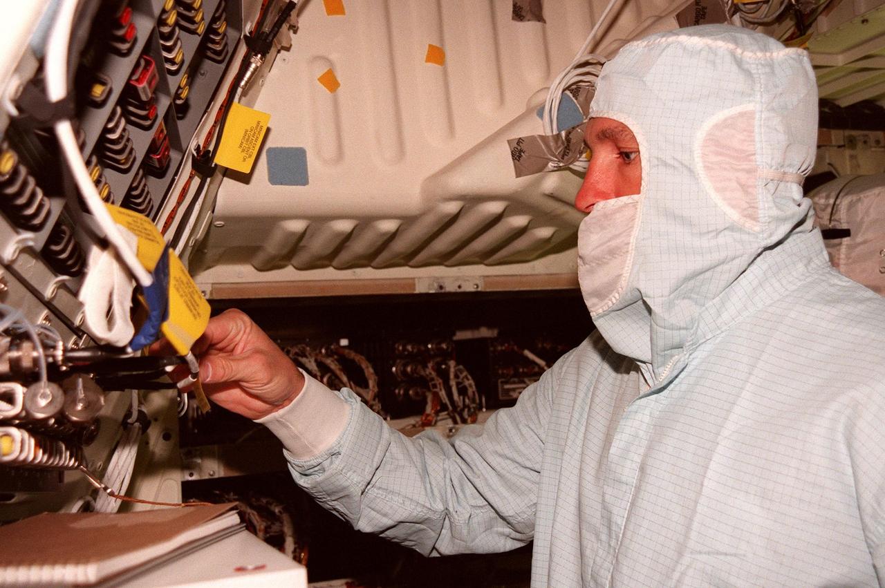 (Foreground) STS-95 Mission Commander Curtis L. Brown Jr. inspects equipment in the orbiter Discovery during a Crew Equipment Interface Test (CEIT) for their mission. The CEIT gives astronauts an opportunity for a hands-on look at the payloads on which they will be working on orbit. The launch of the STS-95 mission, aboard Space Shuttle Discovery, is scheduled for Oct. 29, 1998. The mission includes research payloads such as the Spartan solar-observing deployable spacecraft, the Hubble Space Telescope Orbital Systems Test Platform, the International Extreme Ultraviolet Hitchhiker, as well as the SPACEHAB single module with experiments on space flight and the aging process