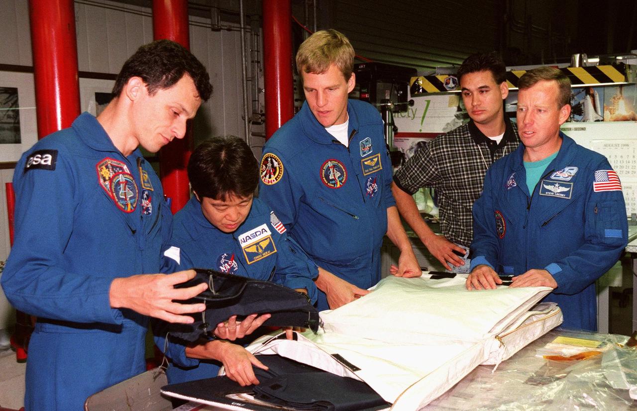 STS-95 crew members look over equipment in Orbiter Processing Facility Bay 2 during the Crew Equipment Interface Test (CEIT) for their mission. From left, they are Mission Specialist Pedro Duque, of the European Space Agency; Payload Specialist Chiaki Mukai, of the National Space Development Agency of Japan (NASDA); Mission Specialist Scott E. Parazynski; and Pilot Steven W. Lindsey. Behind them is Adam Flagan, United Space Alliance-Houston. The CEIT gives astronauts an opportunity for a hands-on look at the payloads and equipment with which they will be working on orbit. The launch of the STS-95 mission, aboard Space Shuttle Discovery, is scheduled for Oct. 29, 1998. The mission includes research payloads such as the Spartan solar-observing deployable spacecraft, the Hubble Space Telescope Orbital Systems Test Platform, the International Extreme Ultraviolet Hitchhiker, as well as the SPACEHAB single module with experiments on space flight and the aging process