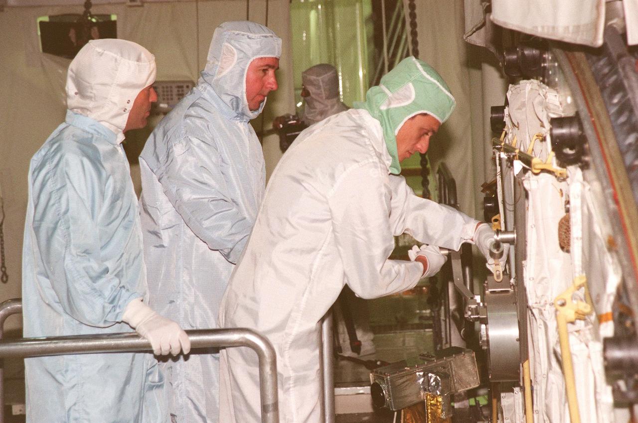 During the Crew Equipment Interface Test (CEIT) in the payload bay of Discovery, STS-95 Mission Specialist Pedro Duque (right), of the European Space Agency, works with a hand crank and cable on the orbiter while Mission Specialist Stephen K. Robinson (center) and Keith Johnson (left), United Space Alliance-Houston, look on. The CEIT gives astronauts an opportunity for a hands-on look at the payloads and equipment with which they will be working on orbit. The launch of the STS-95 mission aboard Space Shuttle Discovery is scheduled for Oct. 29, 1998. The mission includes research payloads such as the Spartan solar-observing deployable spacecraft, the Hubble Space Telescope Orbital Systems Test Platform, the International Extreme Ultraviolet Hitchhiker, as well as the SPACEHAB single module with experiments on space flight and the aging process