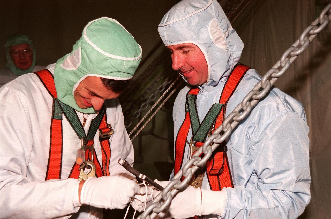 During the Crew Equipment Interface Test (CEIT) in the payload bay of Discovery, STS-95 Mission Specialist Pedro Duque (left), of the European Space Agency, tethers a wrench held by Mission Specialist Stephen K. Robinson (right) that they will use during the mission. The CEIT gives astronauts an opportunity for a hands-on look at the payloads and equipment with which they will be working on orbit. The launch of the STS-95 mission is scheduled for Oct. 29, 1998. The mission includes research payloads such as the Spartan solar-observing deployable spacecraft, the Hubble Space Telescope Orbital Systems Test Platform, the International Extreme Ultraviolet Hitchhiker, as well as the SPACEHAB single module with experiments on space flight and the aging process