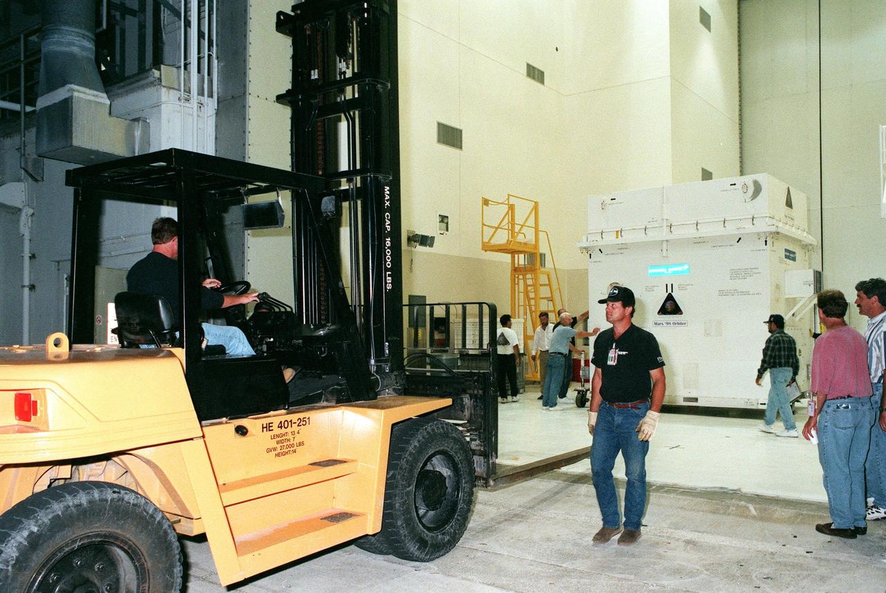 The Mars Climate Orbiter spacecraft is moved into the Spacecraft Assembly and Encapsulation Facility-2 (SAEF-2) in KSC's industrial area. It arrived at the Shuttle Landing Facility aboard an Air Force C-17 cargo plane early this morning following its flight from the Lockheed Martin Astronautics plant in Denver, Colo. When it arrives at the red planet, the Mars Climate Orbiter will primarily support its companion Mars Polar Lander spacecraft, planned for launch on Jan. 3, 1999. After that, the Mars Climate Orbiter's instruments will monitor the Martian atmosphere and image the planet's surface on a daily basis for one Martian year (1.8 Earth years). It will observe the appearance and movement of atmospheric dust and water vapor, as well as characterize seasonal changes on the surface. The detailed images of the surface features will provide important clues to the planet's early climate history and give scientists more information about possible liquid water reserves beneath the surface. The scheduled launch date for the Mars Climate Orbiter is Dec. 10, 1998, on a Delta II 7425 rocket