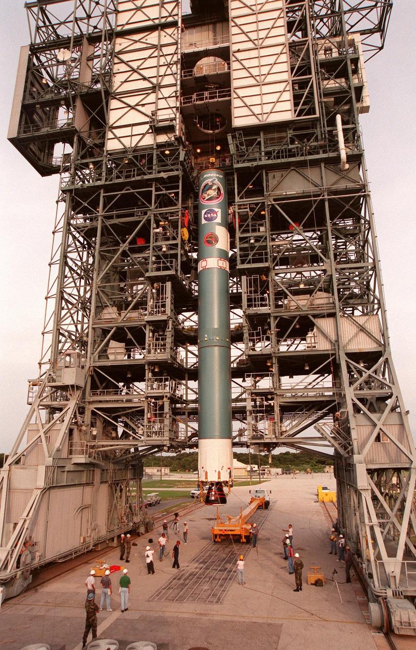 The first stage of Boeing's Delta 7326 rocket, which will be used to launch the Deep Space 1 spacecraft, is lifted into place above the surface of Pad 17A at Cape Canaveral Air Station. Targeted for launch on Oct. 15, 1998, this first flight in NASA's New Millennium Program is designed to validate 12 new technologies for scientific space missions of the next century. Onboard experiments include an ion propulsion engine and software that tracks celestial bodies so the spacecraft can make its own navigation decisions without the intervention of ground controllers. Deep Space 1 will complete most of its mission objectives within the first two months but will also do a flyby of a near-Earth asteroid, 1992 KD, in July 1999