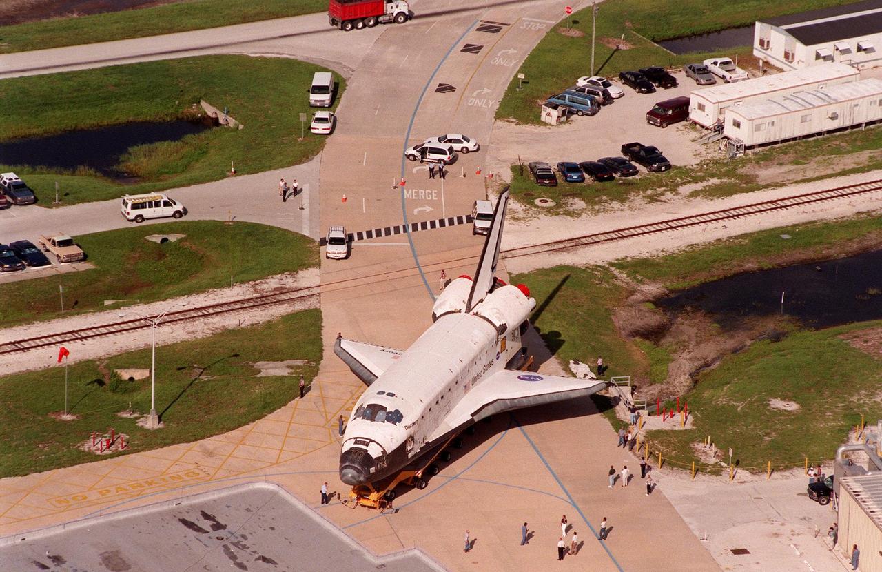 Rollover of the orbiter Discovery from the Orbiter Processing Facility Bay 2 to the Vehicle Assembly Building draws the attention of KSC employees. The orbiter displays the recently painted NASA logo, termed the "meatball," on its left wing and both sides of the fuselage. Discovery (OV-103) is scheduled for its 25th flight, from Launch Pad 39B, on Oct. 29, 1998, for the STS-95 mission
