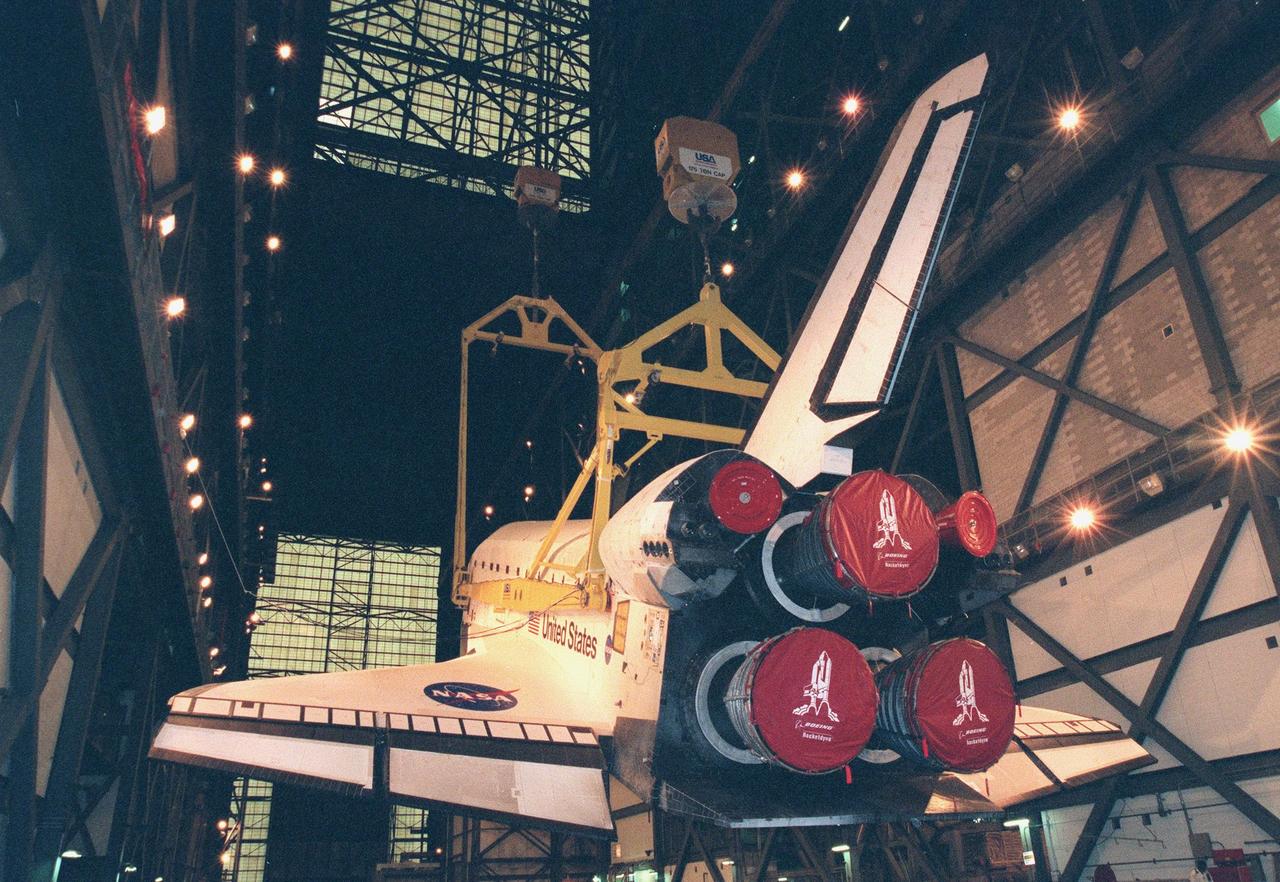 In the Vehicle Assembly Building, the orbiter Discovery (viewed from behind the Space Shuttle Main Engines, port side) is raised to a vertical position in order to be mated with the external tank. The orbiter displays the recently painted NASA logo, termed the "meatball," on its left, or port, wing. The logo also has been painted on both sides of the aft fuselage. Discovery (OV-103), the first of the orbiters to be launched with the new art work, is scheduled for its 25th flight, from Launch Pad 39B, on Oct. 29, 1998, for the STS-95 mission