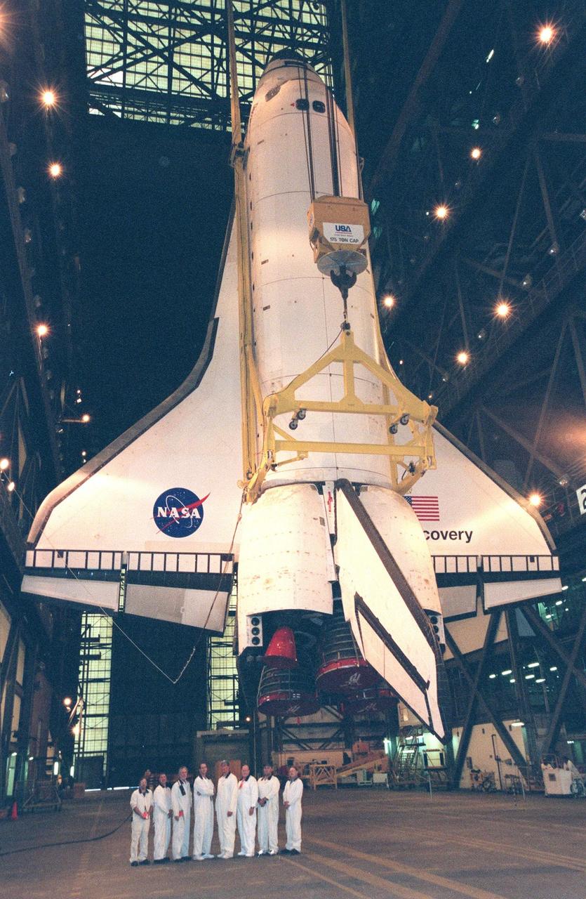 United Space Alliance Forward Shop workers stand near the orbiter Discovery in the Vehicle Assembly Building . The orbiter is being prepared for mating with the external tank. Discovery displays the recently painted NASA logo, termed the "meatball," on its left, or port, wing. The logo also has been painted on both sides of the aft fuselage. Discovery (OV-103), the first of the orbiters to be launched with the new art work, is scheduled for its 25th flight, from Launch Pad 39B, on Oct. 29, 1998, for the STS-95 mission