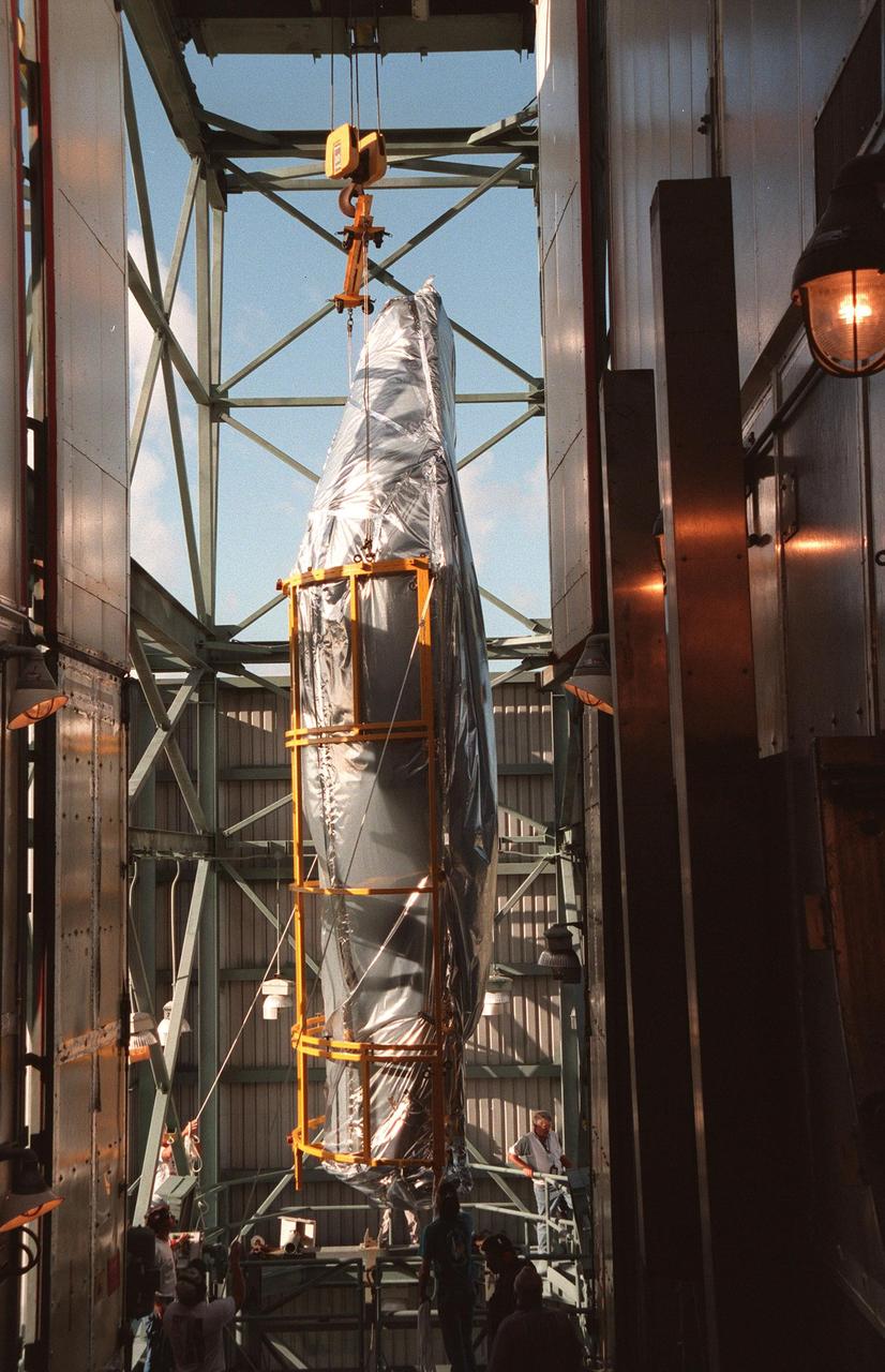 KENNEDY SPACE CENTER, FLA. -- The fairing for Deep Space 1 nears the top of the Mobile Service Tower before being attached to the Boeing Delta 7326 rocket that will launch on Oct. 15, 1998. The first flight in NASA's New Millennium Program, Deep Space 1 is designed to validate 12 new technologies for scientific space missions of the next century. Onboard experiments include an ion propulsion engine and software that tracks celestial bodies so the spacecraft can make its own navigation decisions without the intervention of ground controllers. Deep Space 1 will complete most of its mission objectives within the first two months, but will also do a flyby of a near-Earth asteroid, 1992 KD, in July 1999
