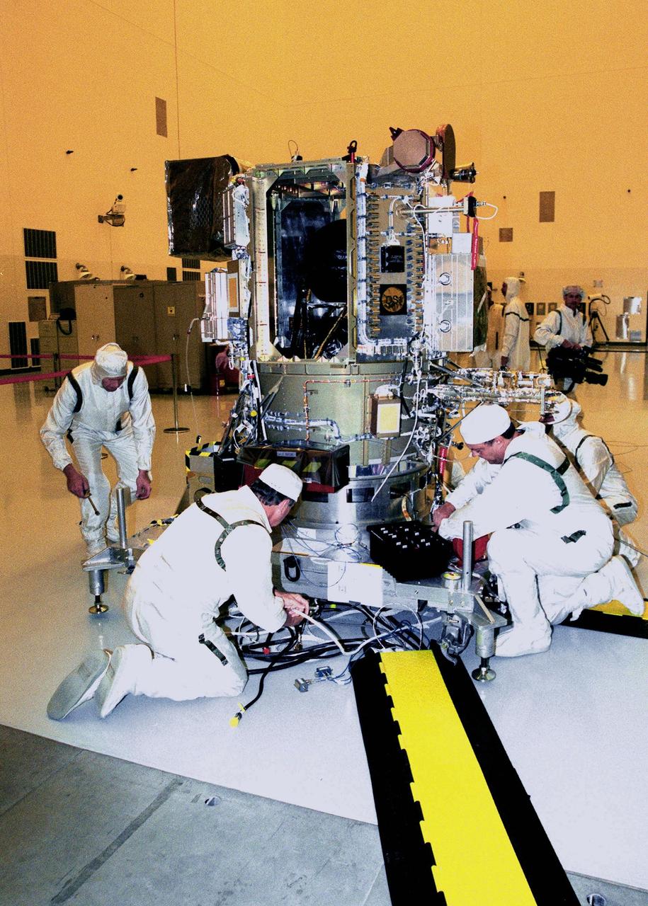 KENNEDY SPACE CENTER, FLA. -- Workers in the Payload Hazardous Servicing Facility check equipment on Deep Space 1 to prepare it for launch aboard a Boeing Delta 7326 rocket in October. The first flight in NASA's New Millennium Program, Deep Space 1 is designed to validate 12 new technologies for scientific space missions of the next century. Onboard experiments include an ion propulsion engine and software that tracks celestial bodies so the spacecraft can make its own navigation decisions without the intervention of ground controllers. Most of its mission objectives will be completed within the first two months. A near-Earth asteroid, 1992 KD, has also been selected for a possible flyby