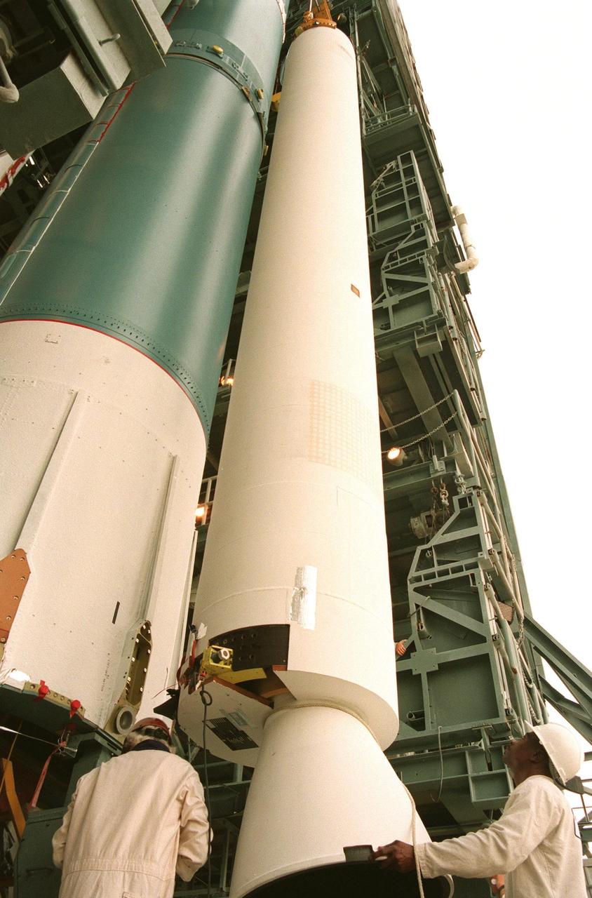 A solid rocket booster is maneuvered into place for installation on the Boeing Delta 7326 rocket that will launch Deep Space 1 at Launch Pad 17A, Cape Canaveral Air Station. Delta II rockets are medium capacity expendable launch vehicles derived from the Delta family of rockets built and launched since 1960. Since then there have been more than 245 Delta launches. Delta's origins go back to the Thor intermediate-range ballistic missile, which was developed in the mid-1950s for the U.S. Air Force. The Thor a single-stage, liquid-fueled rocket later was modified to become the Delta launch vehicle. The Delta 7236 has three solid rocket boosters and a Star 37 upper stage. Delta IIs are manufactured in Huntington Beach, Calif. Rocketdyne, a division of The Boeing Company, builds Delta II's main engine in Canoga Park, Calif. Final assembly takes place at the Boeing facility in Pueblo, Colo. Deep Space 1, the first flight in NASA's New Millennium Program, is designed to validate 12 new technologies for scientific space missions of the next century. Onboard experiments include an ion propulsion engine and software that tracks celestial bodies so the spacecraft can make its own navigation decisions without the intervention of ground controllers. Deep Space 1 will complete most of its mission objectives within the first two months, but may also do a flyby of a near-Earth asteroid, 1992 KD, in July 1999