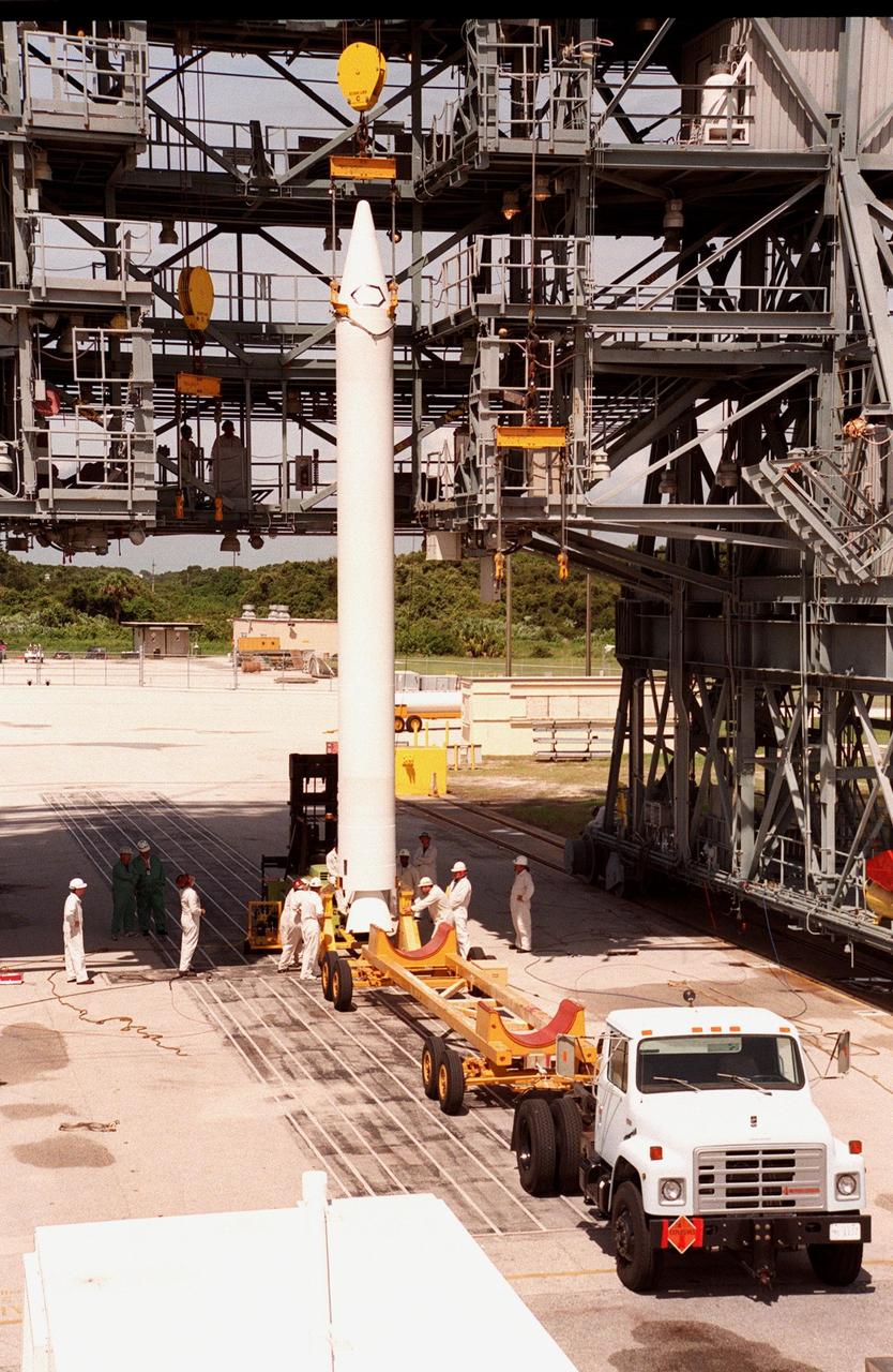 A booster is raised off a truck bed and prepared for lifting to the Boeing Delta 7326 rocket that will launch Deep Space 1 at Launch Pad 17A, Cape Canaveral Air Station. Delta II rockets are medium capacity expendable launch vehicles derived from the Delta family of rockets built and launched since 1960. Since then there have been more than 245 Delta launches. The Delta 7236 has three solid rocket boosters and a Star 37 upper stage. Delta IIs are manufactured in Huntington Beach, Calif. Rocketdyne, a division of The Boeing Company, builds Delta II's main engine in Canoga Park, Calif. Deep Space 1, the first flight in NASA's New Millennium Program, is designed to validate 12 new technologies for scientific space missions of the next century. Onboard experiments include an ion propulsion engine and software that tracks celestial bodies so the spacecraft can make its own navigation decisions without the intervention of ground controllers. Deep Space 1 will complete most of its mission objectives within the first two months, but may also do a flyby of a near-Earth asteroid, 1992 KD, in July 1999